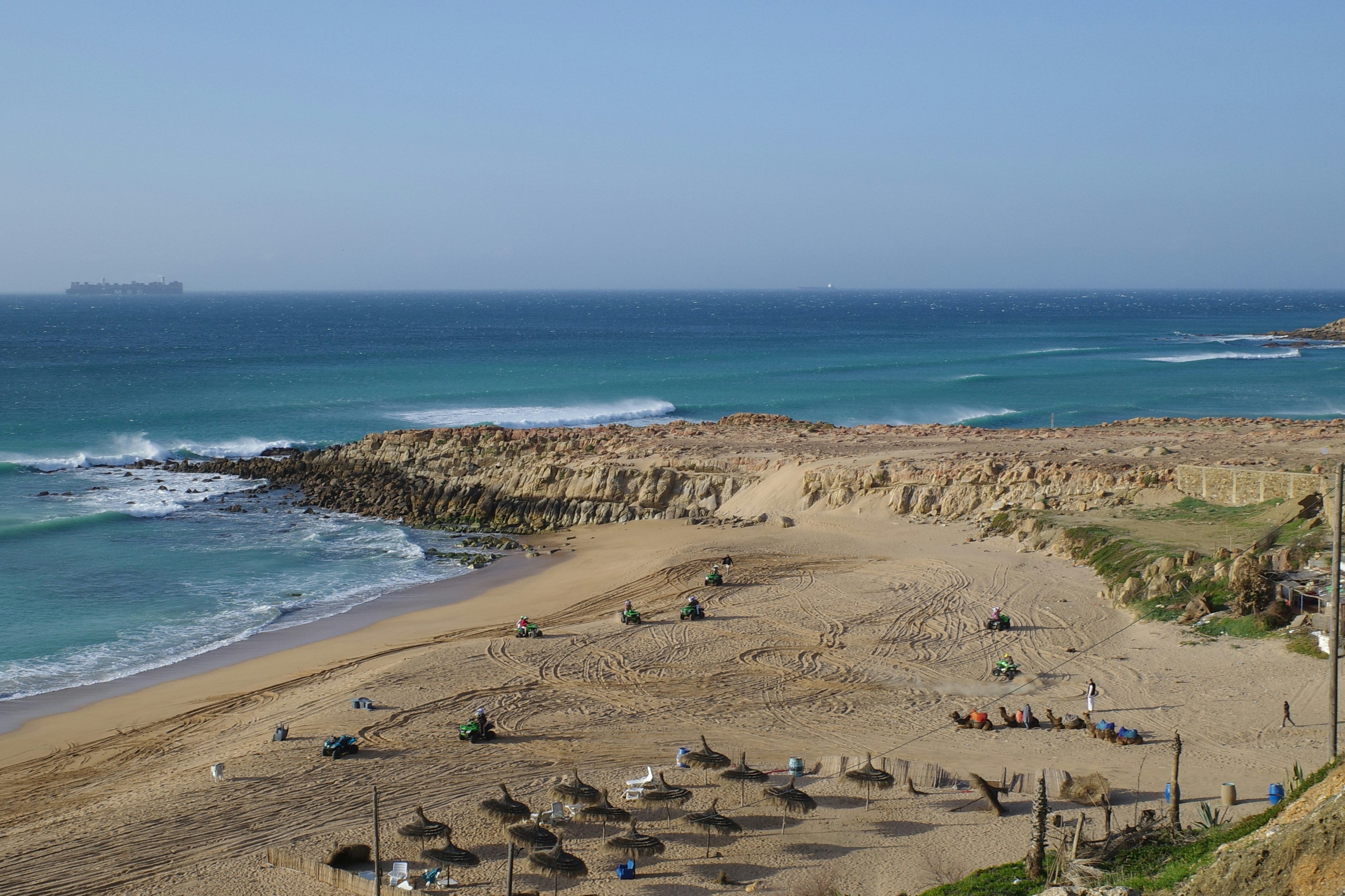 Sandy beach with rocky coastline and blue ocean