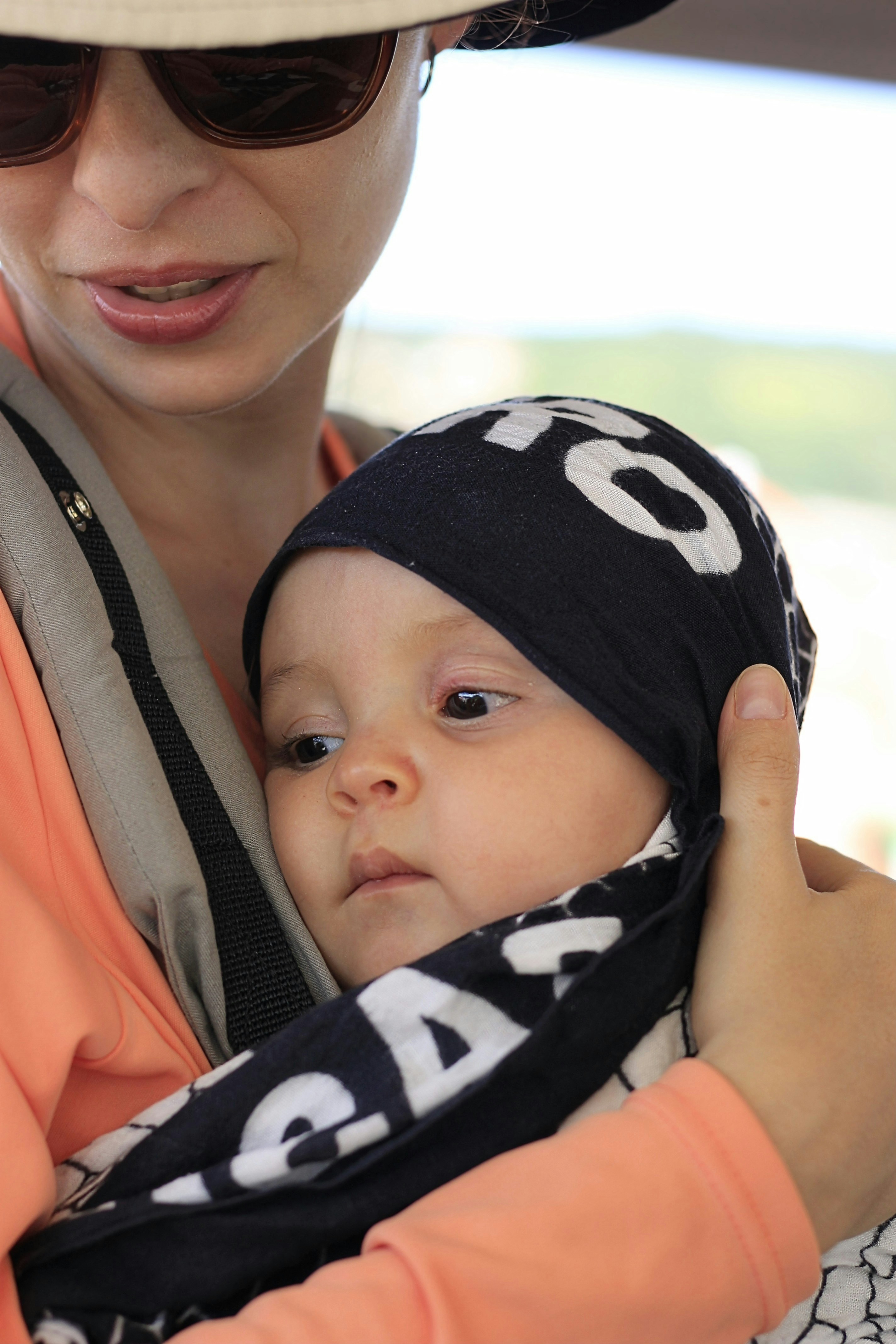 Mãe segurando um bebê em um carregador de bandoleiro