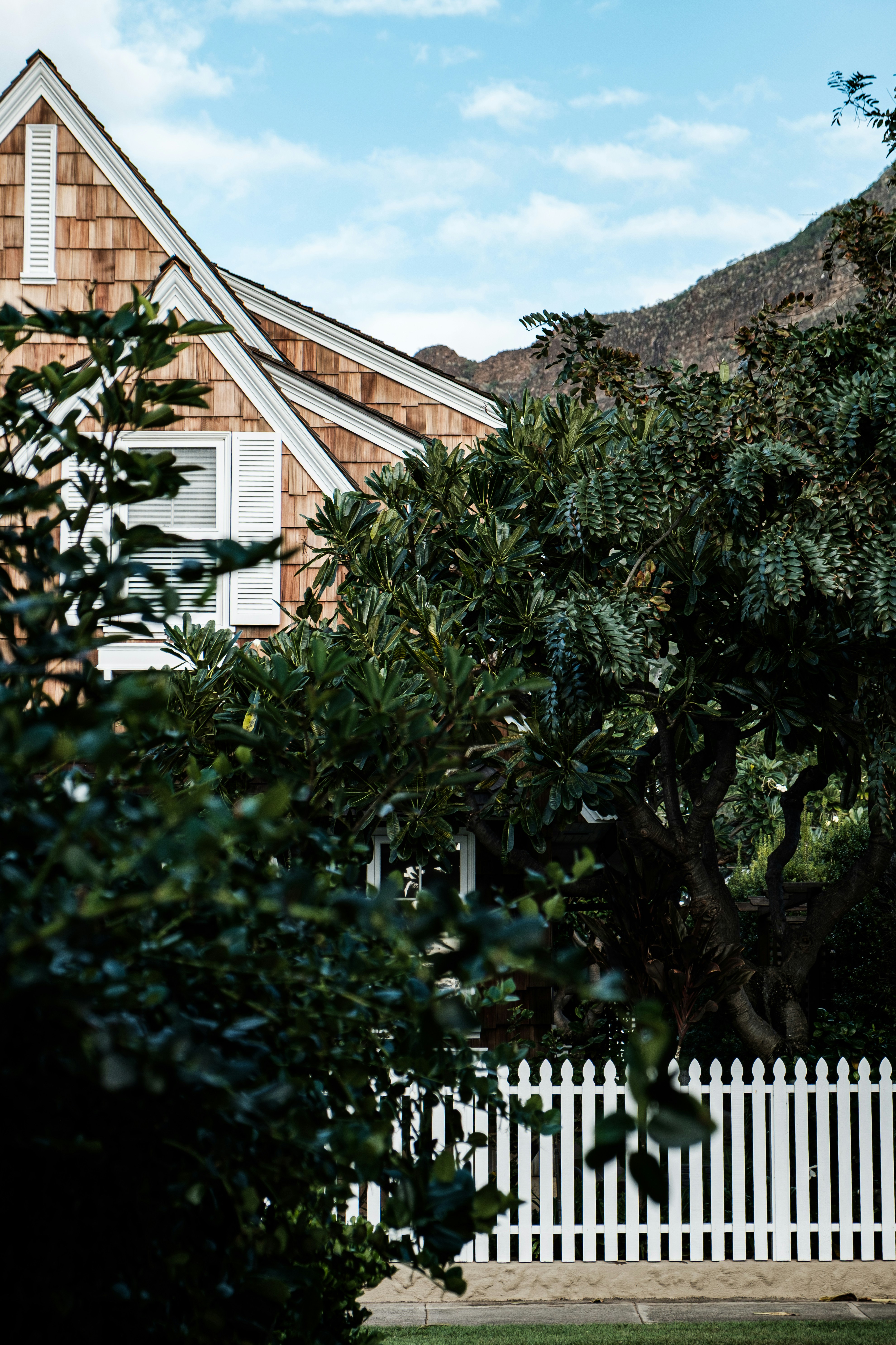 Une maison en bois avec une clôture blanche.