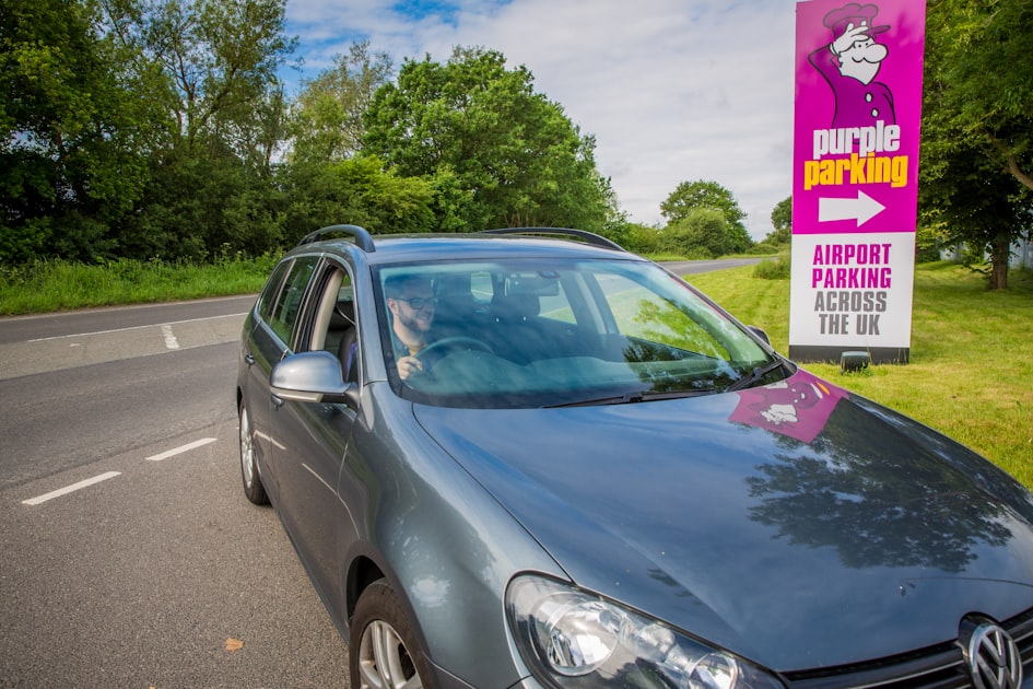Car driving past purple parking sign