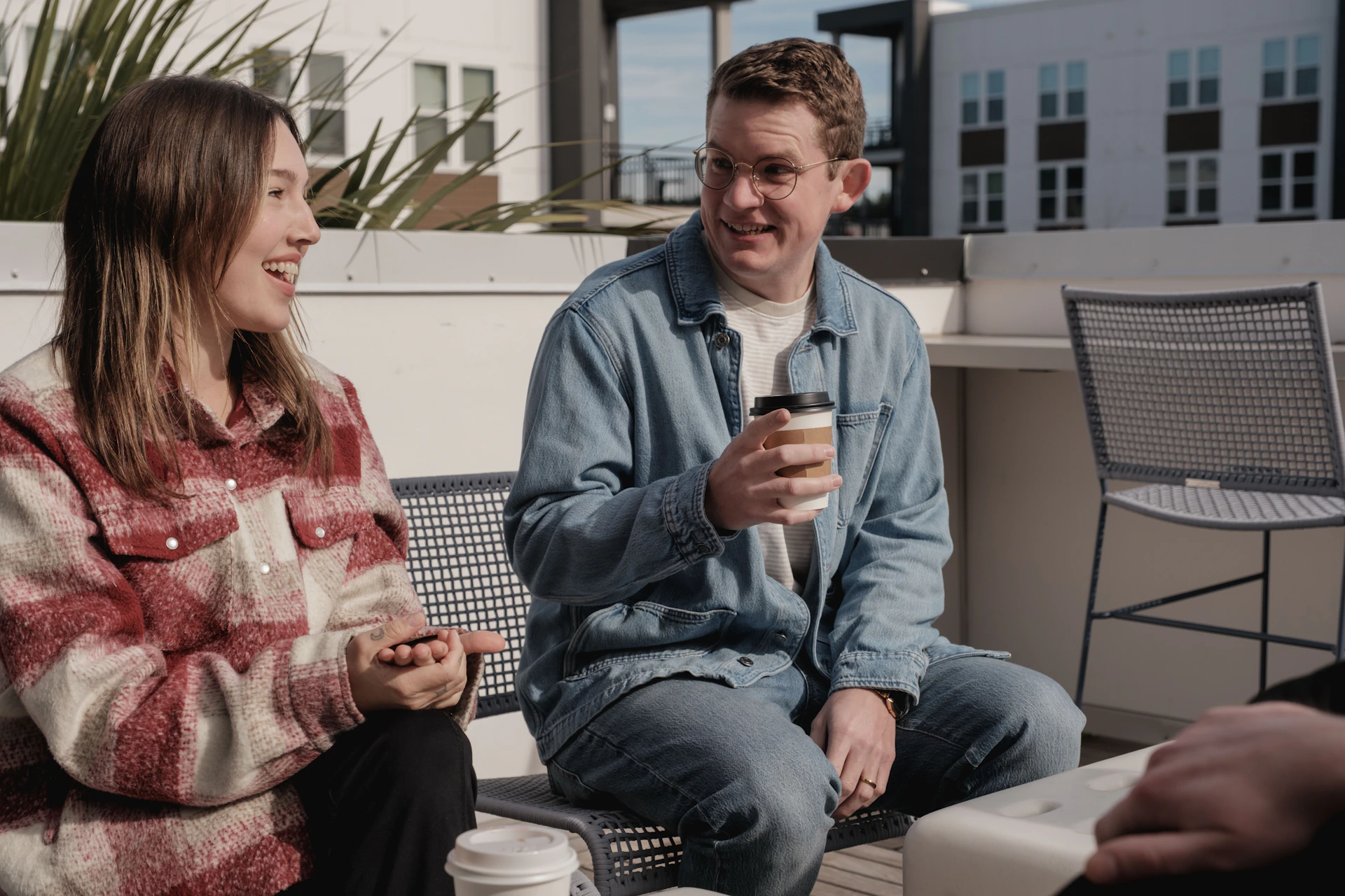 Two people sitting and talking on a rooftop