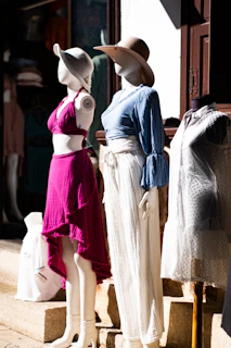 Mannequins in stylish summer outfits displayed outside.
