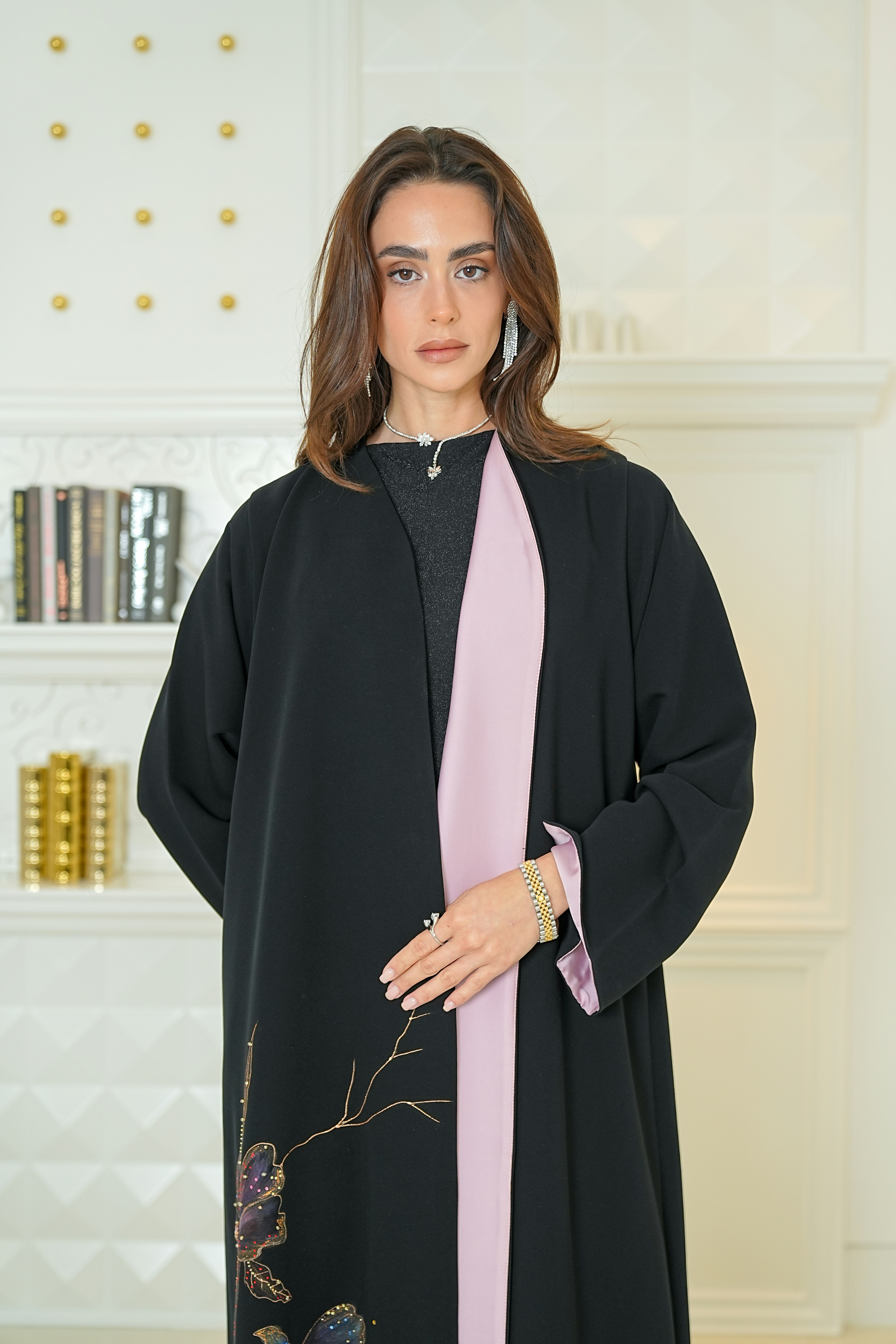 Woman wearing a stylish black abaya with pink accents