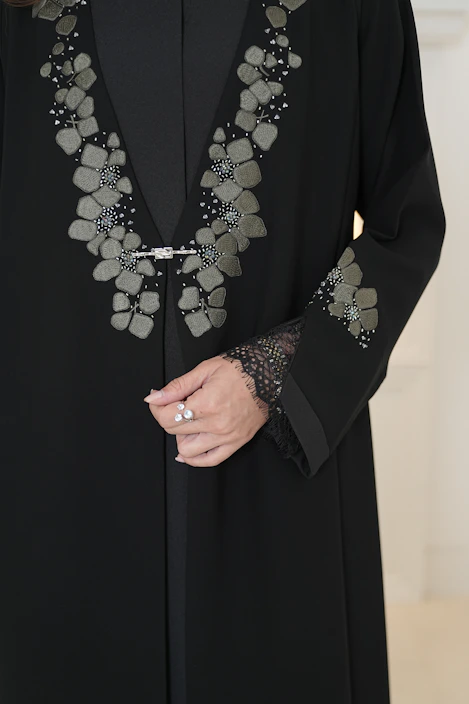 Elegant black abaya with floral embellishments and lace cuffs