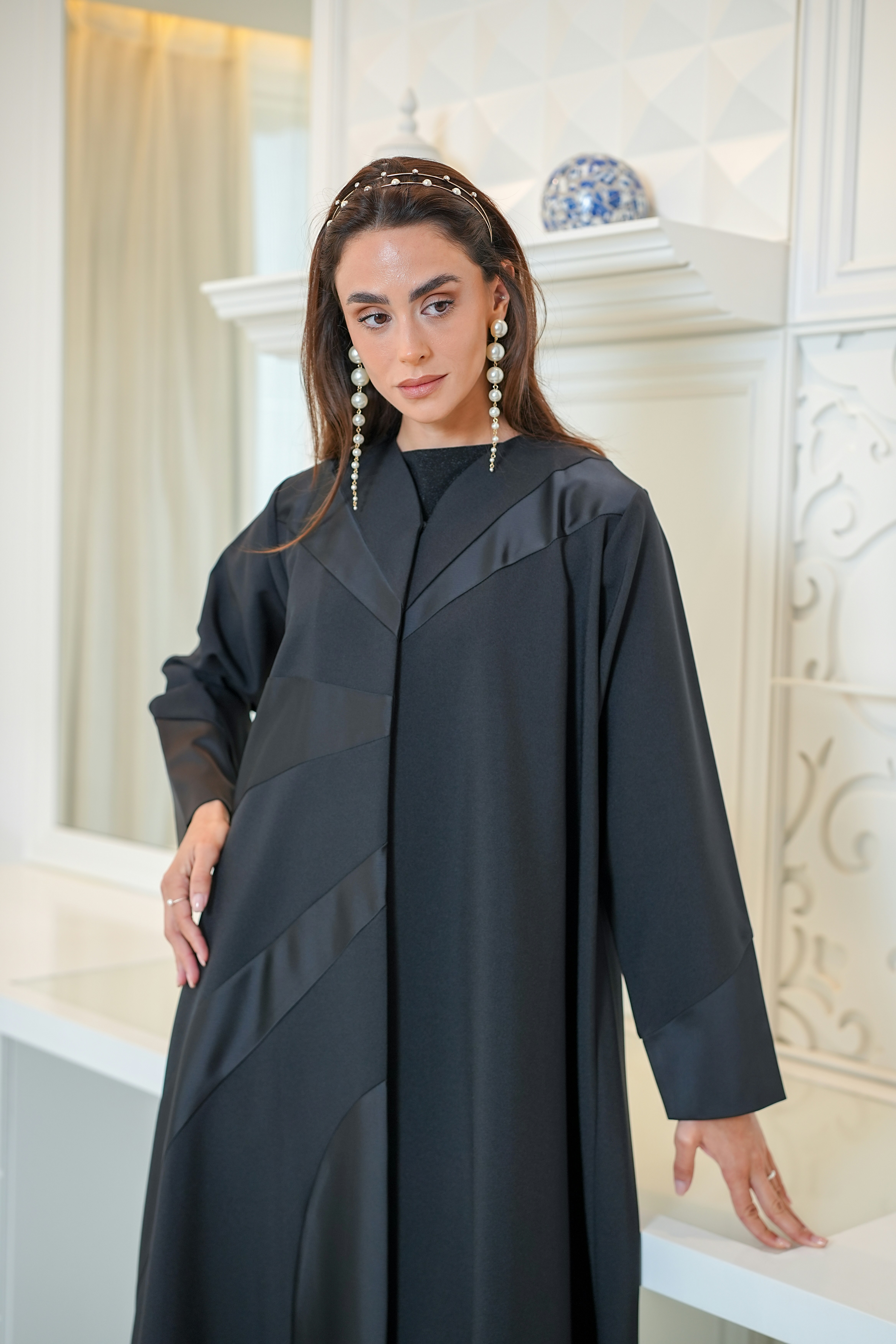 A woman wearing a black abaya with a headband.