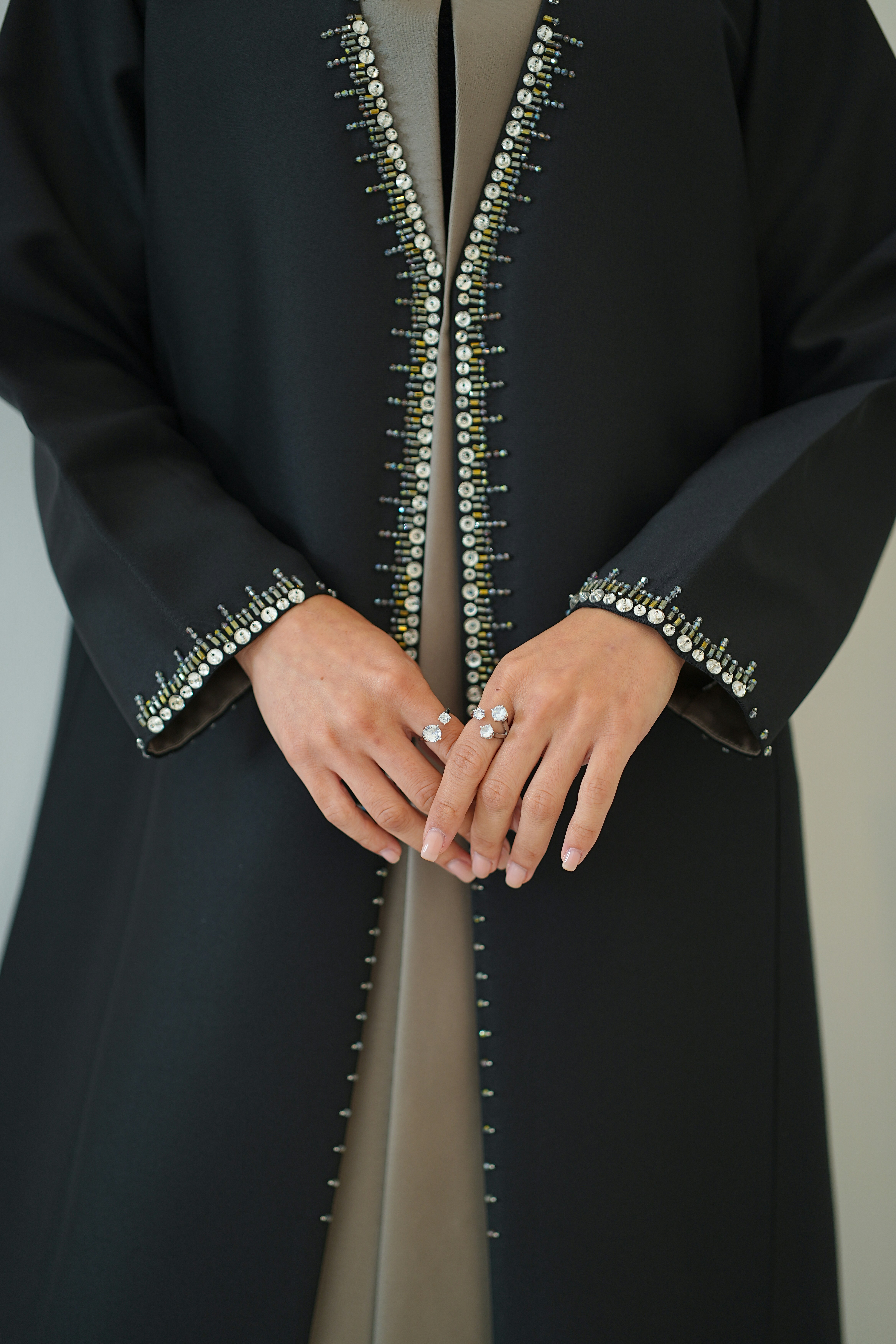 Black abaya with pearl and bead embellishments on sleeves.