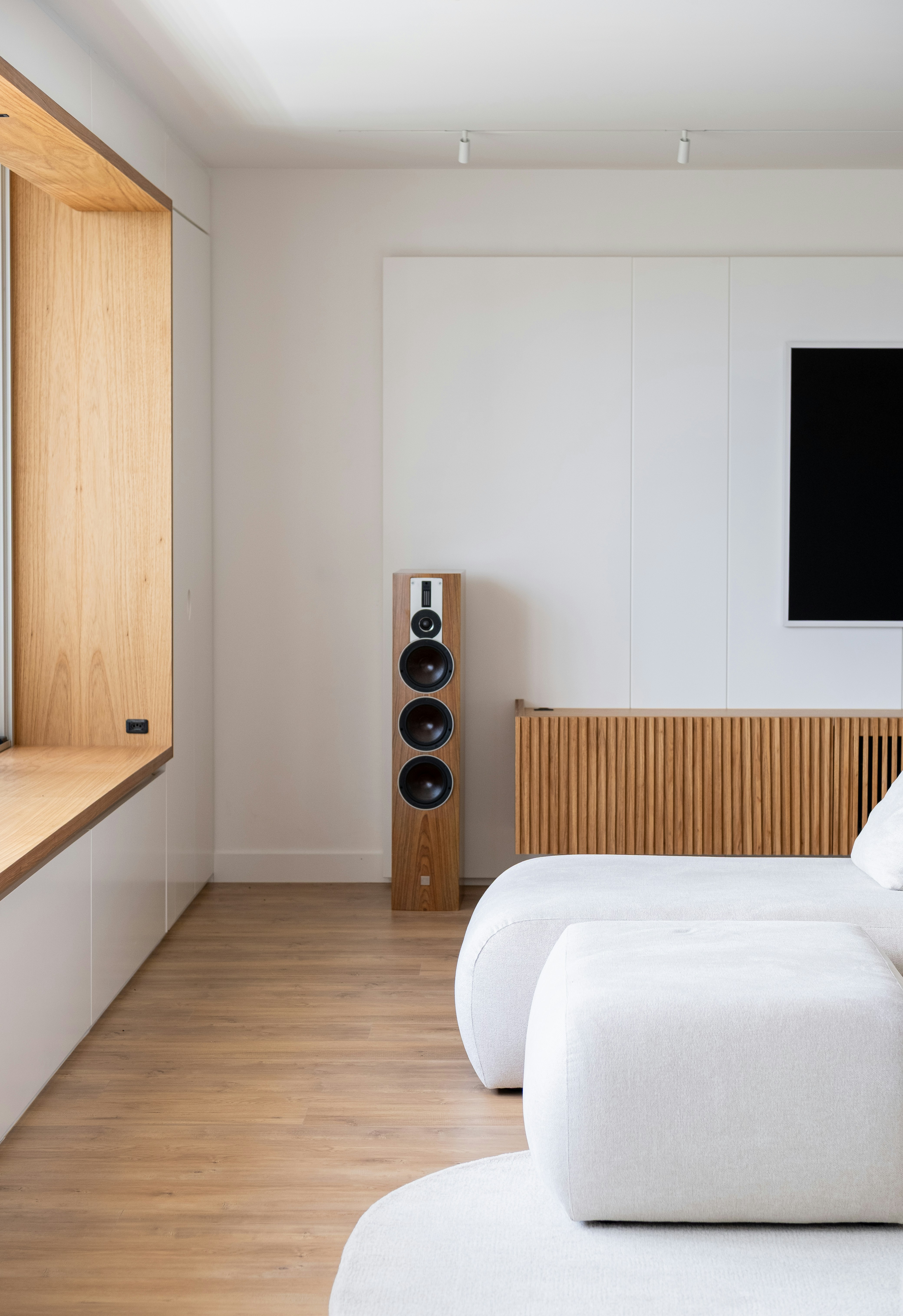 木製のアクセントと白い家具が特徴のモダンなリビングルーム