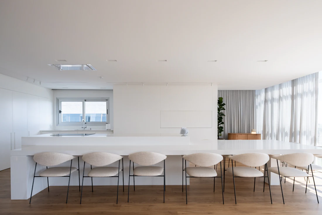 Sala de jantar clara com mesa longa e luz natural