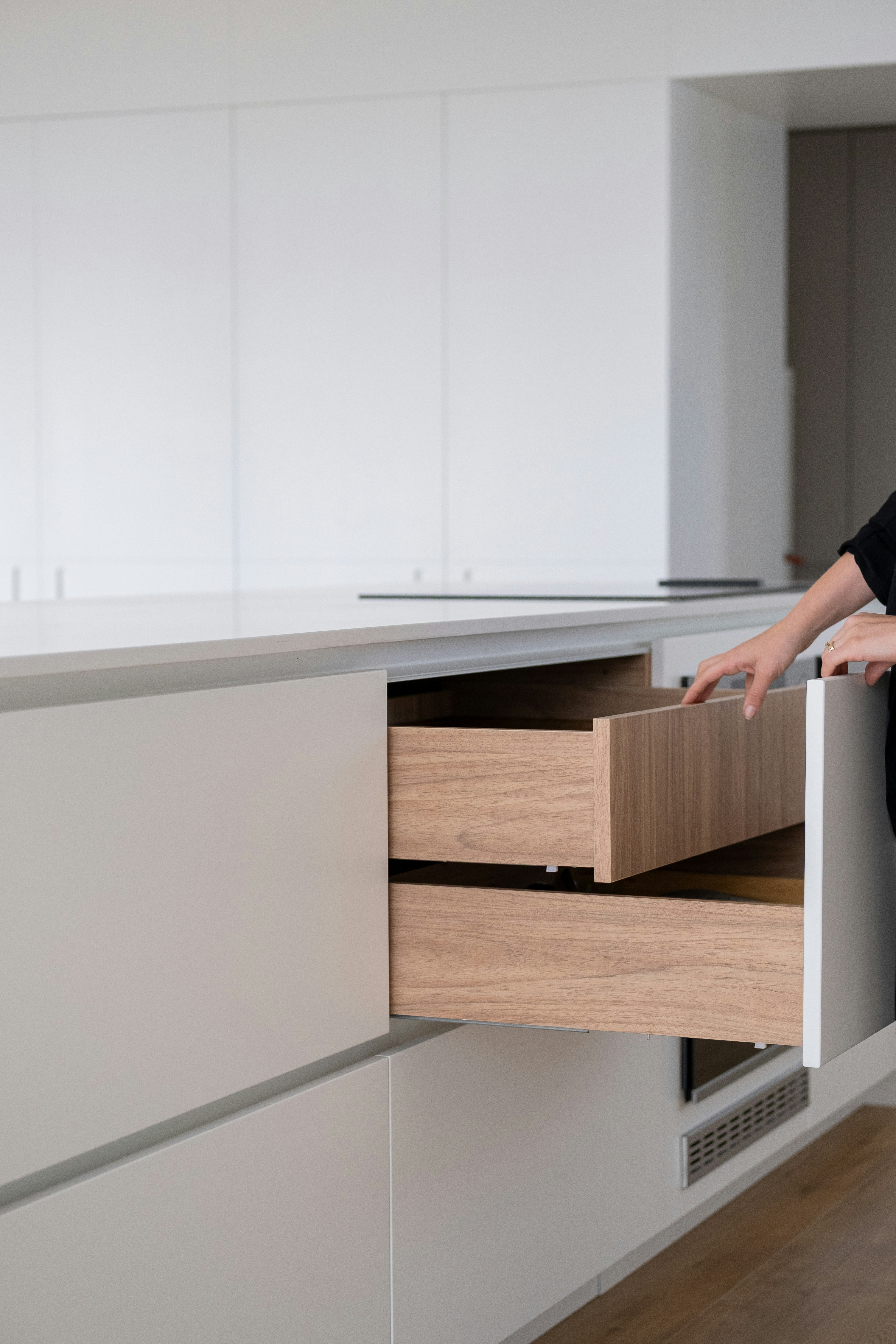 現代的なキッチンの引き出しを開ける人がいます