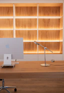 Modern desk with computer and illuminated shelves