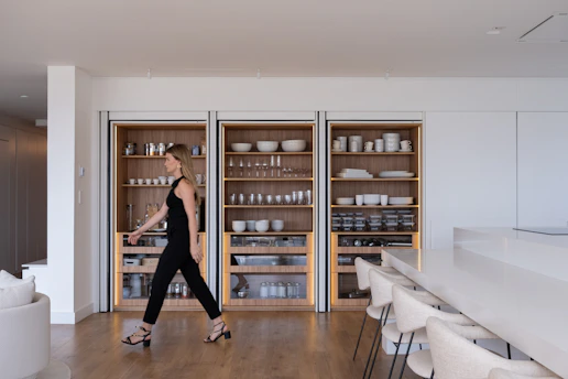 Woman walking past modern built-in shelving