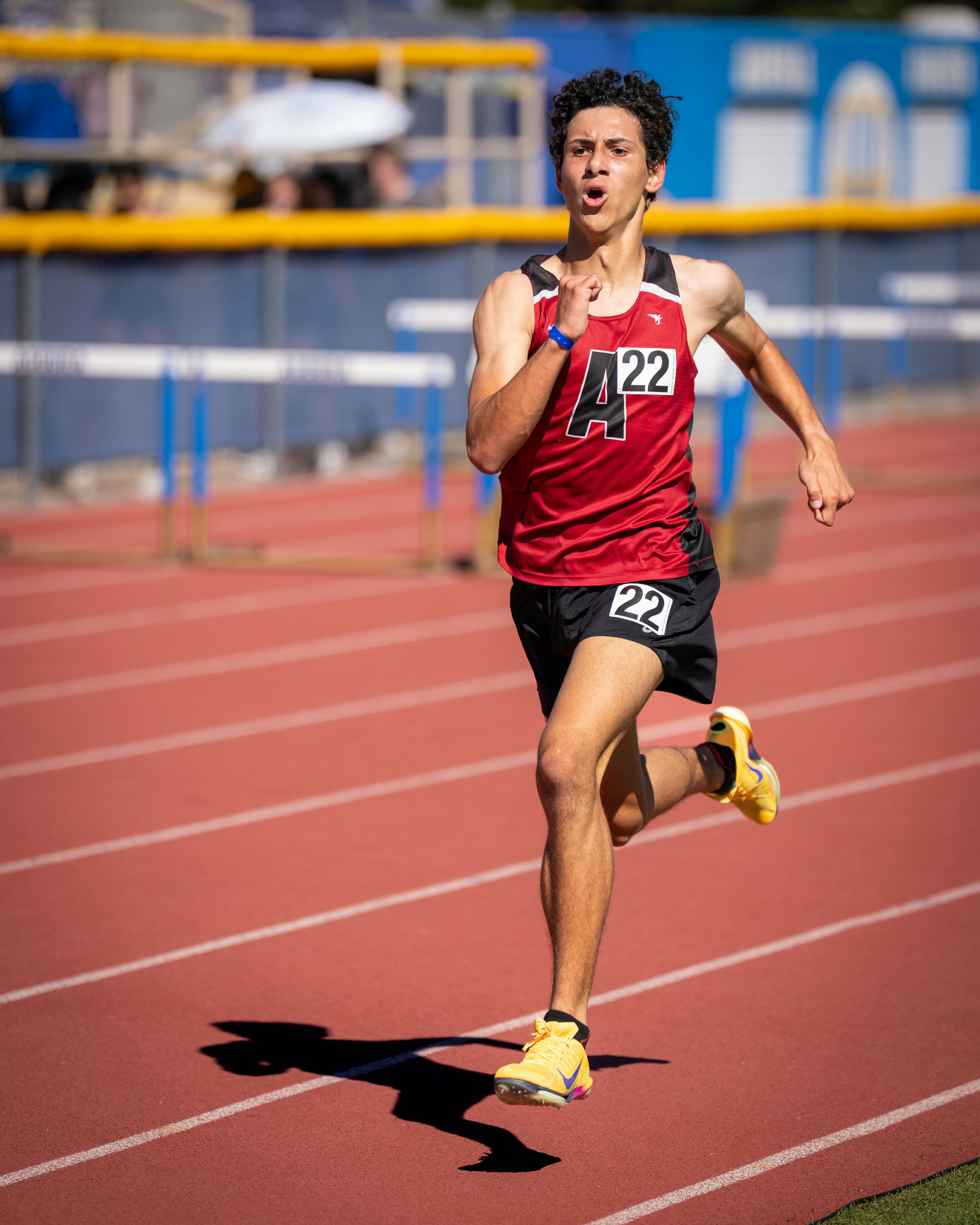 Young male runner competes on a track.