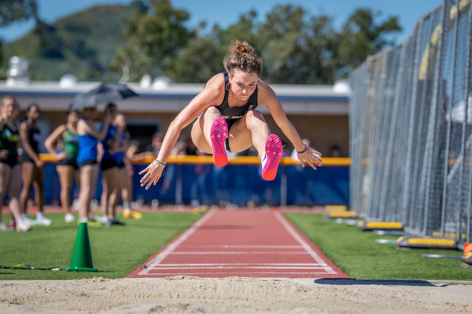 Athlete mid-jump during a long jump competition