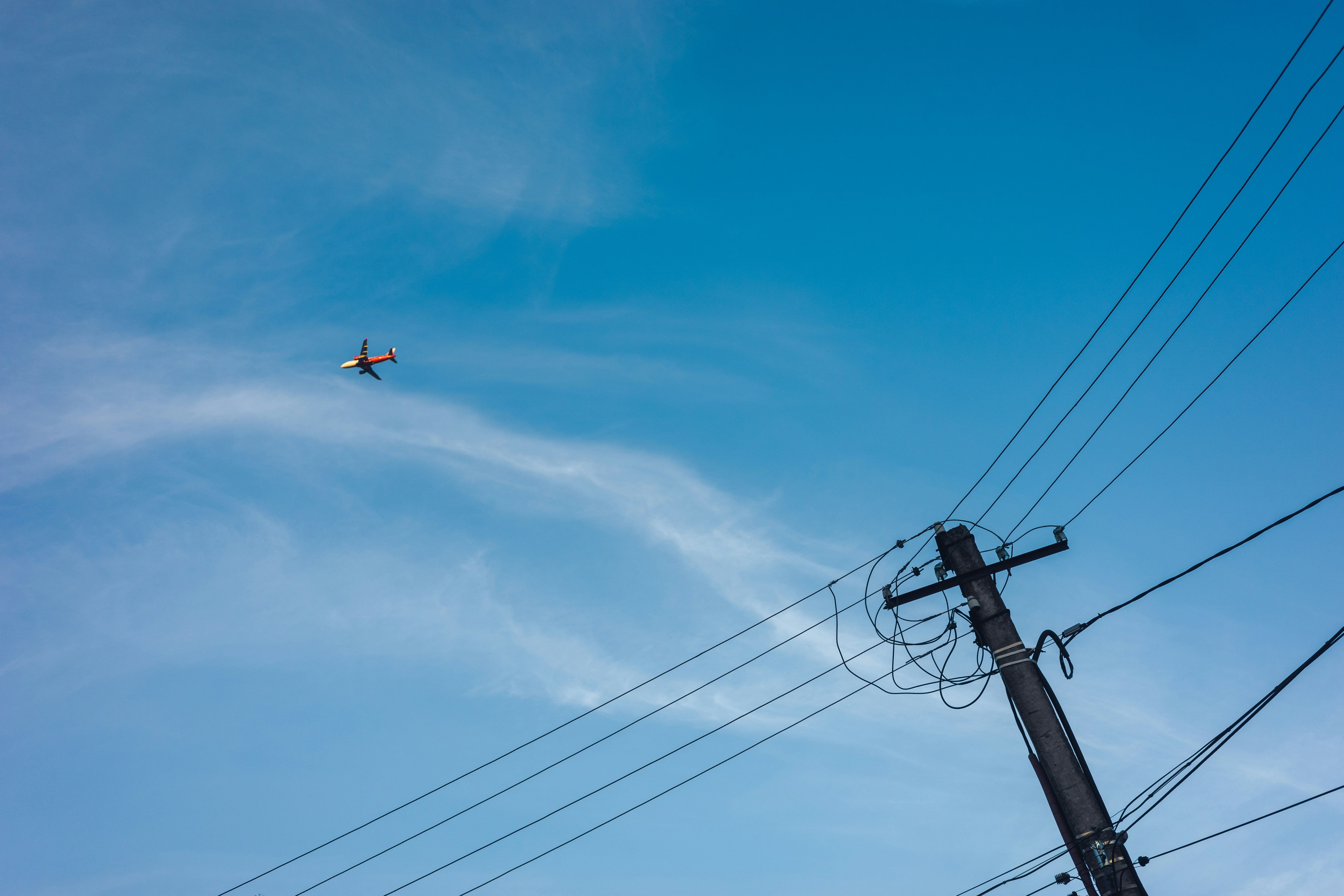 Airplane flying in the sky near power lines.