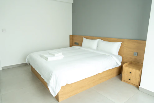 A neatly made bed in a modern hotel room.