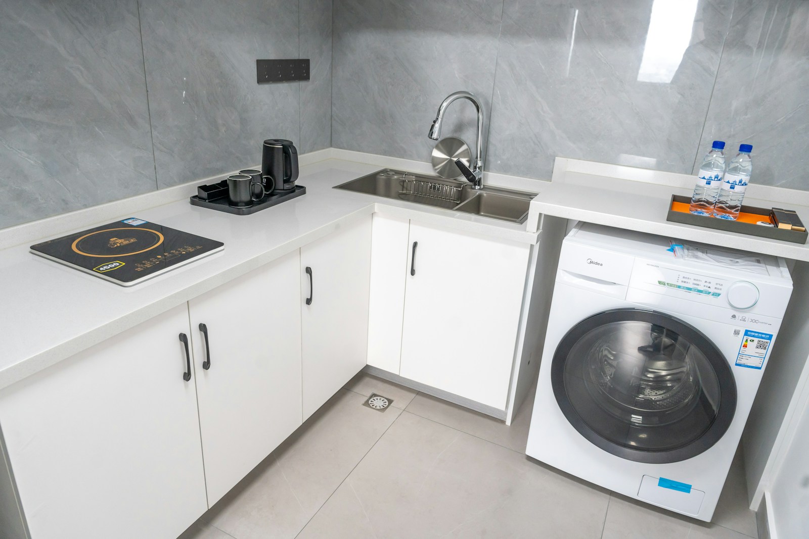 compact apartment kitchenette with white cabinets stove and washing machine