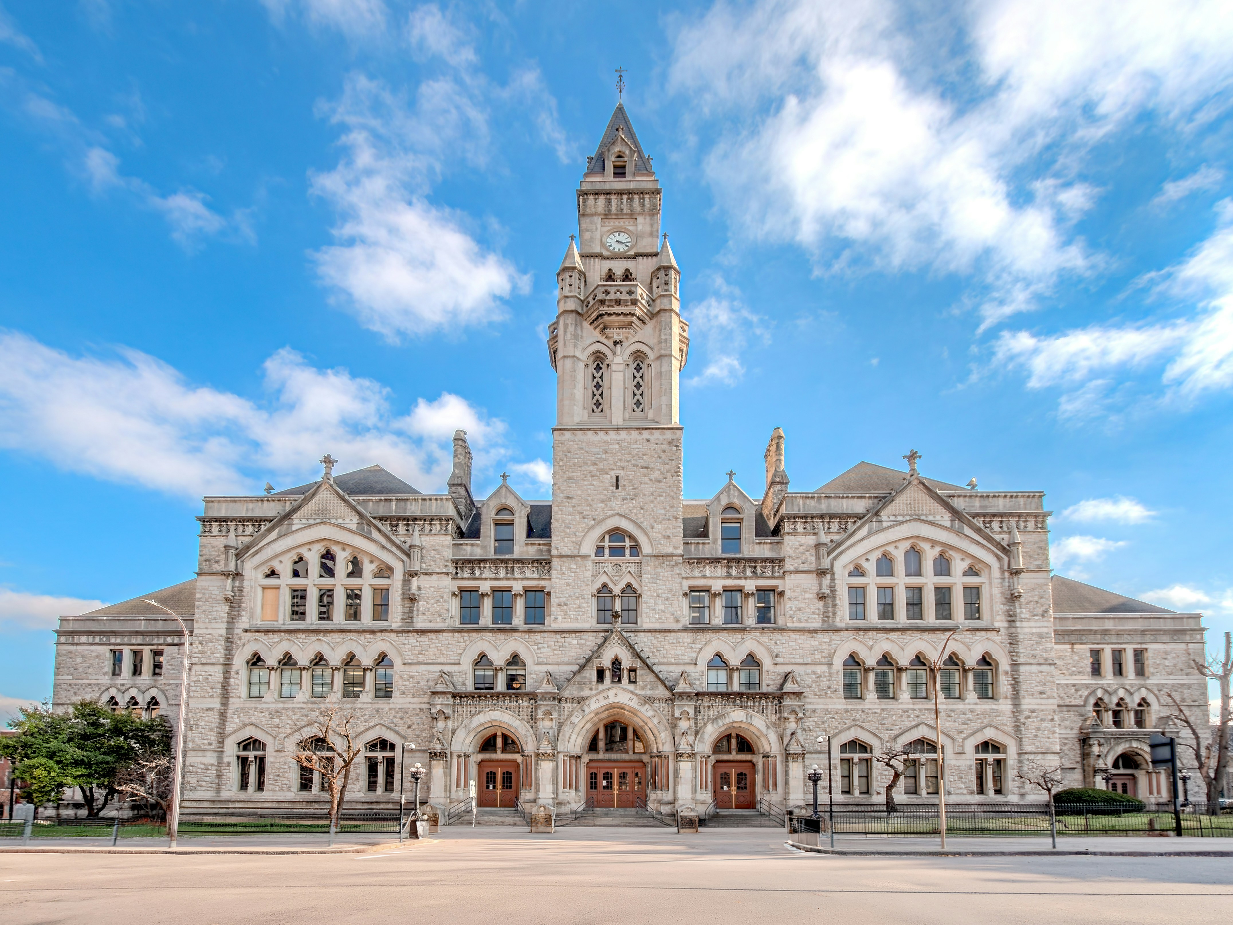 Grand stone building with a tall clock tower.