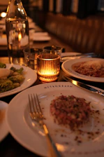 A table set for dinner with a lit candle.