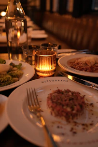 A table set for dinner with a lit candle.