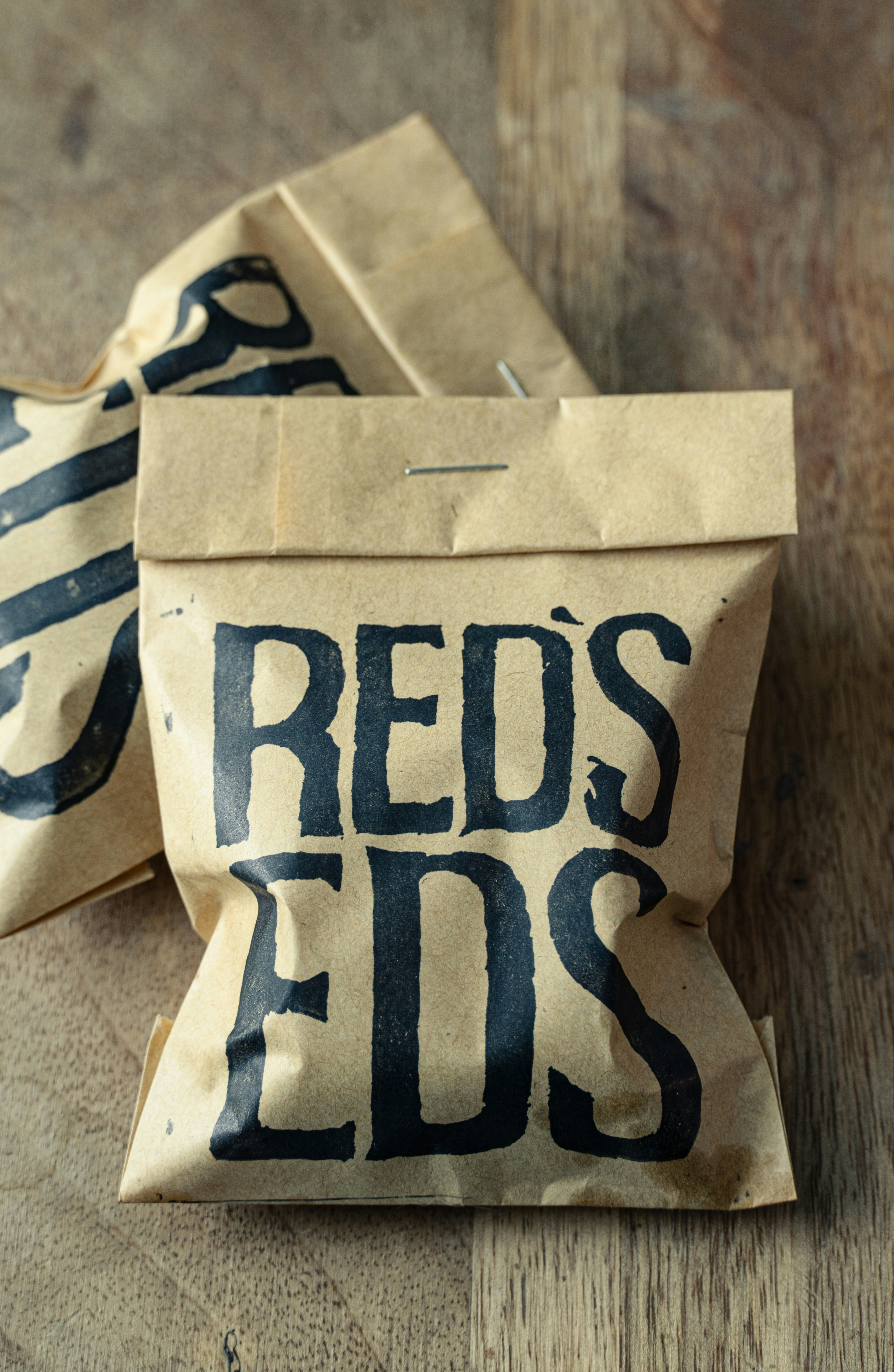 Dos bolsas de papel marrón con texto negro.