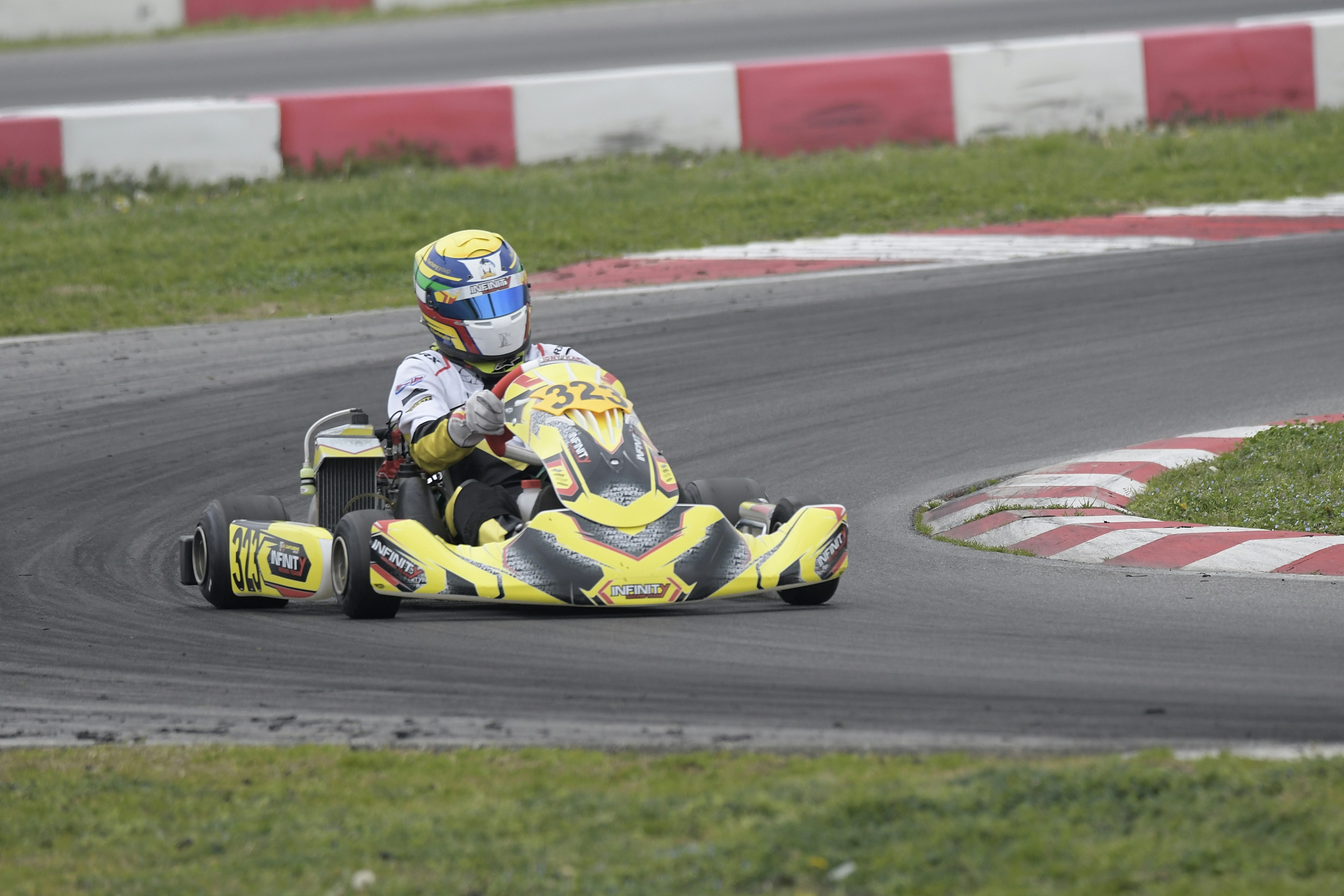 A go-kart racer speeds around a track corner.