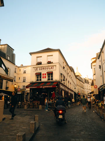 Rua parisiense com fachadas antigas e uma scooter