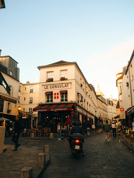 Rua parisiense com fachadas antigas e uma scooter