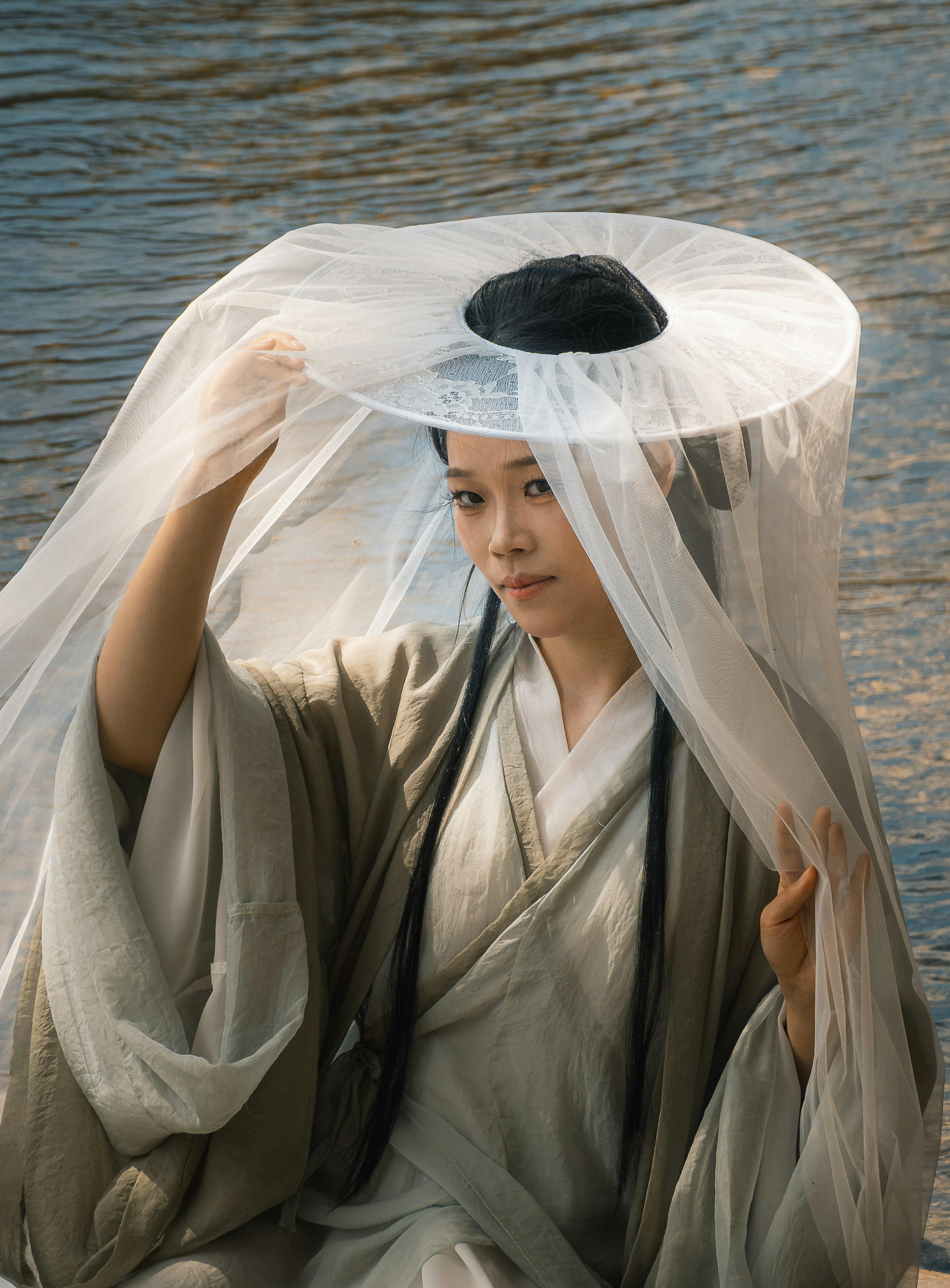 Woman in traditional asian attire by the water
