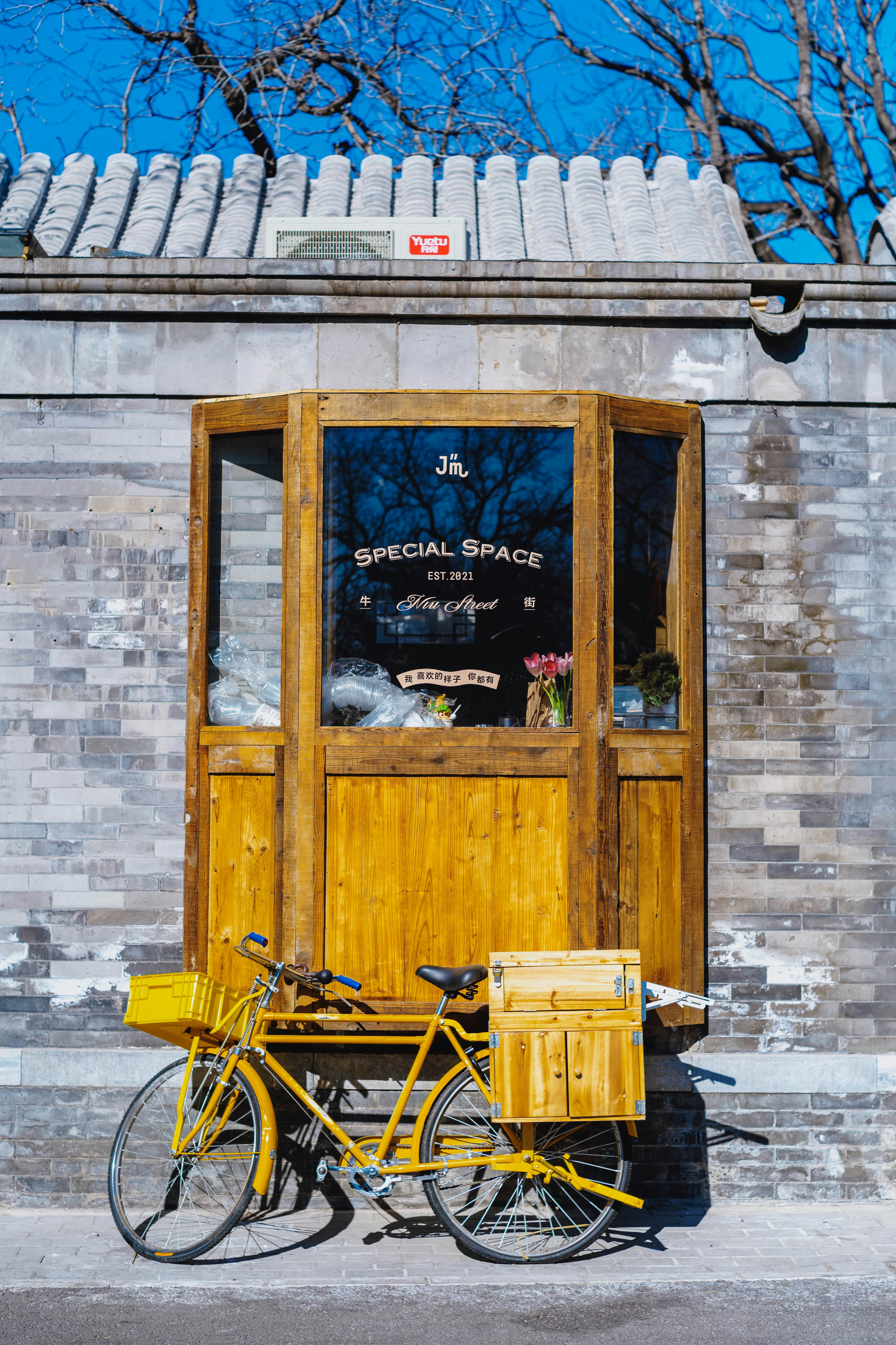 Vélo jaune garé devant une vitrine en bois