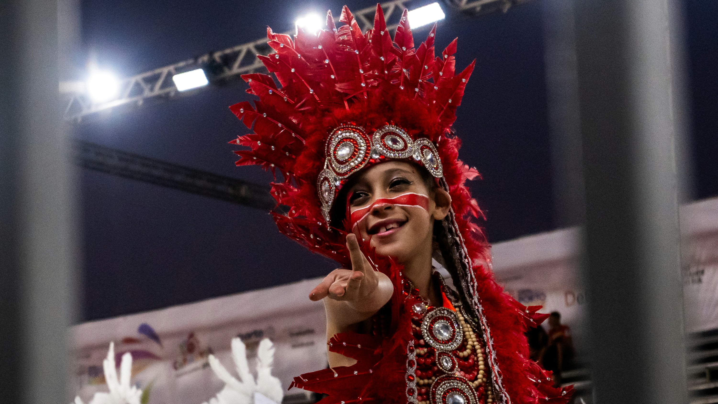 Seorang anak dengan hiasan kepala dan kostum merah cerah