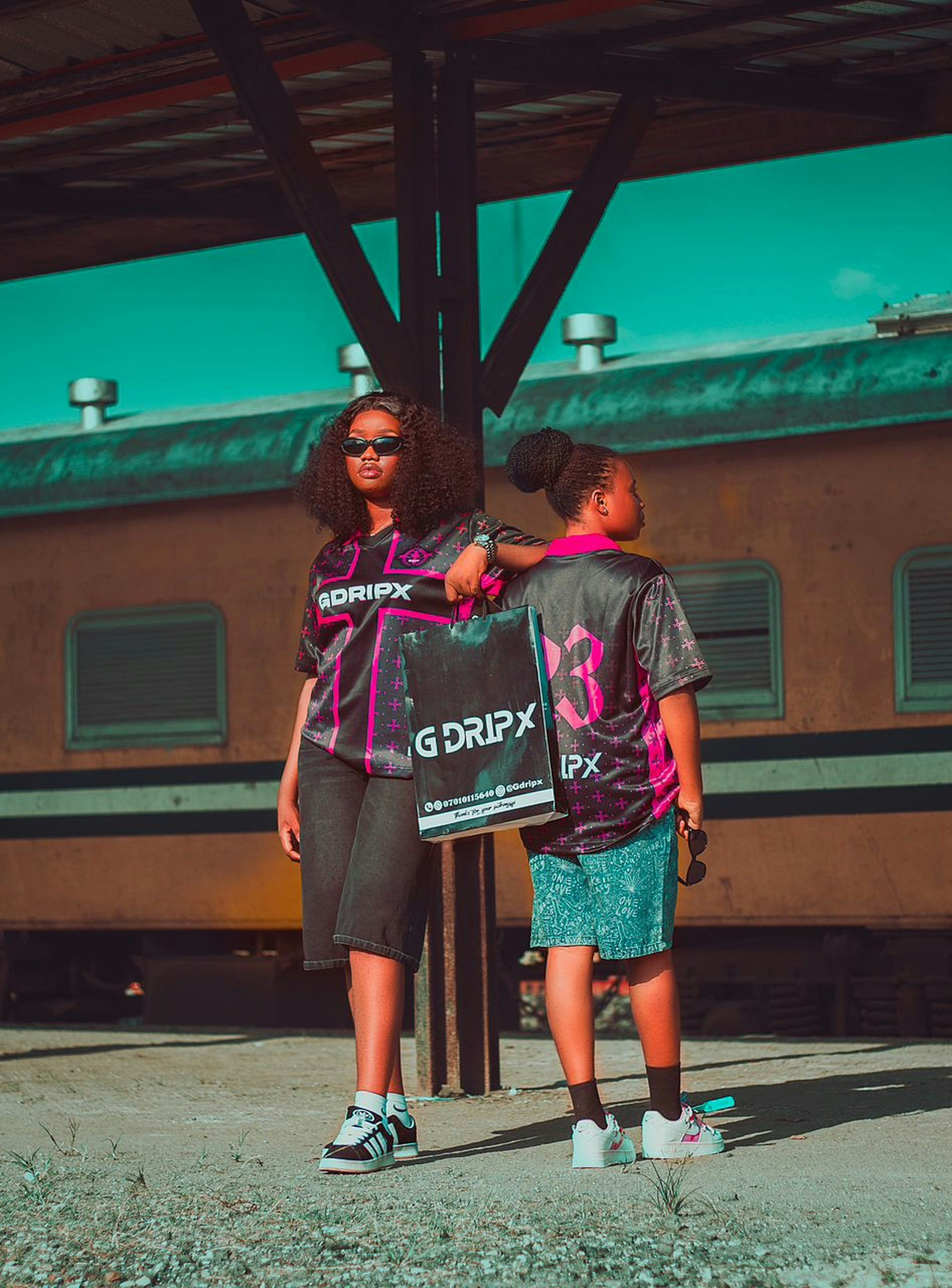 Duas jovens mulheres em roupas esportivas estão perto de um trem.