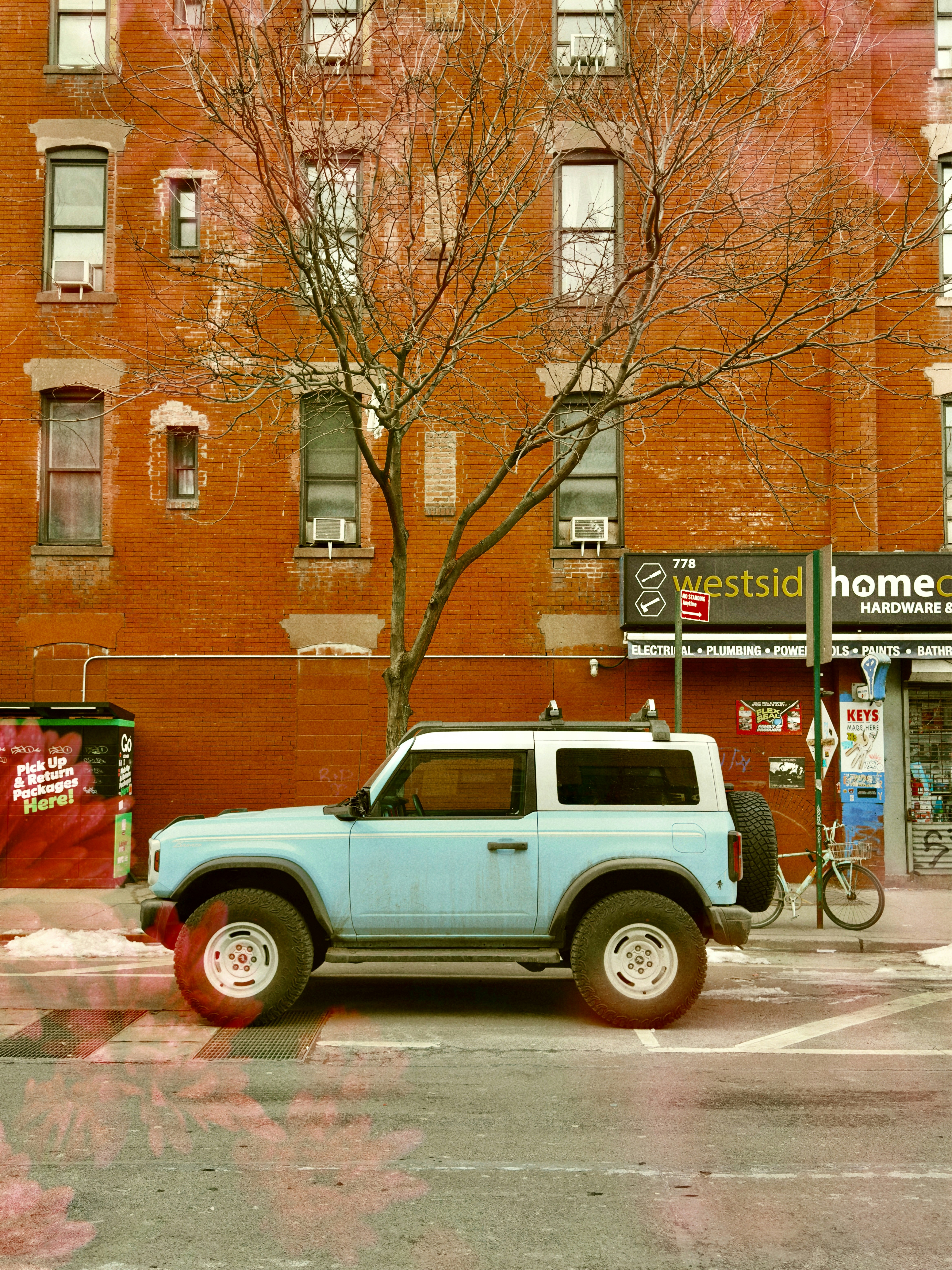 Light blue suv parked on a city street.