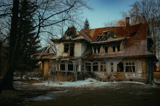 An old, dilapidated house with a damaged roof.