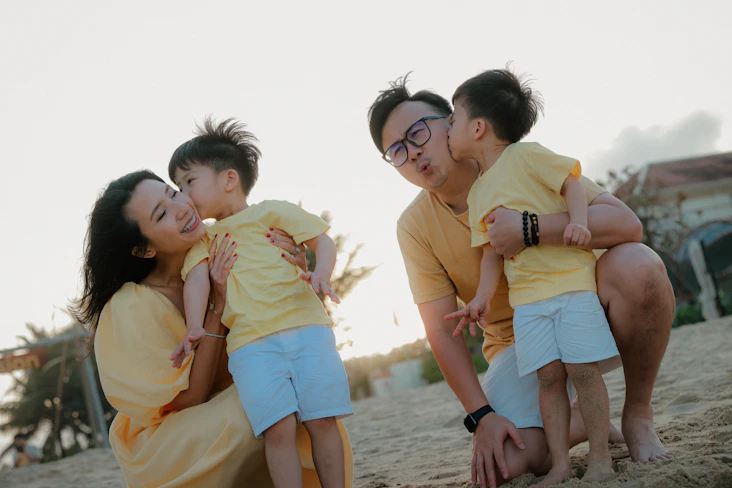 Family in yellow outfits on a beach at sunset