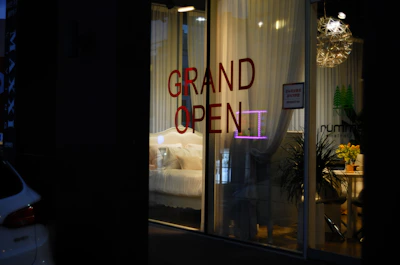 Grand open sign in a lit storefront window