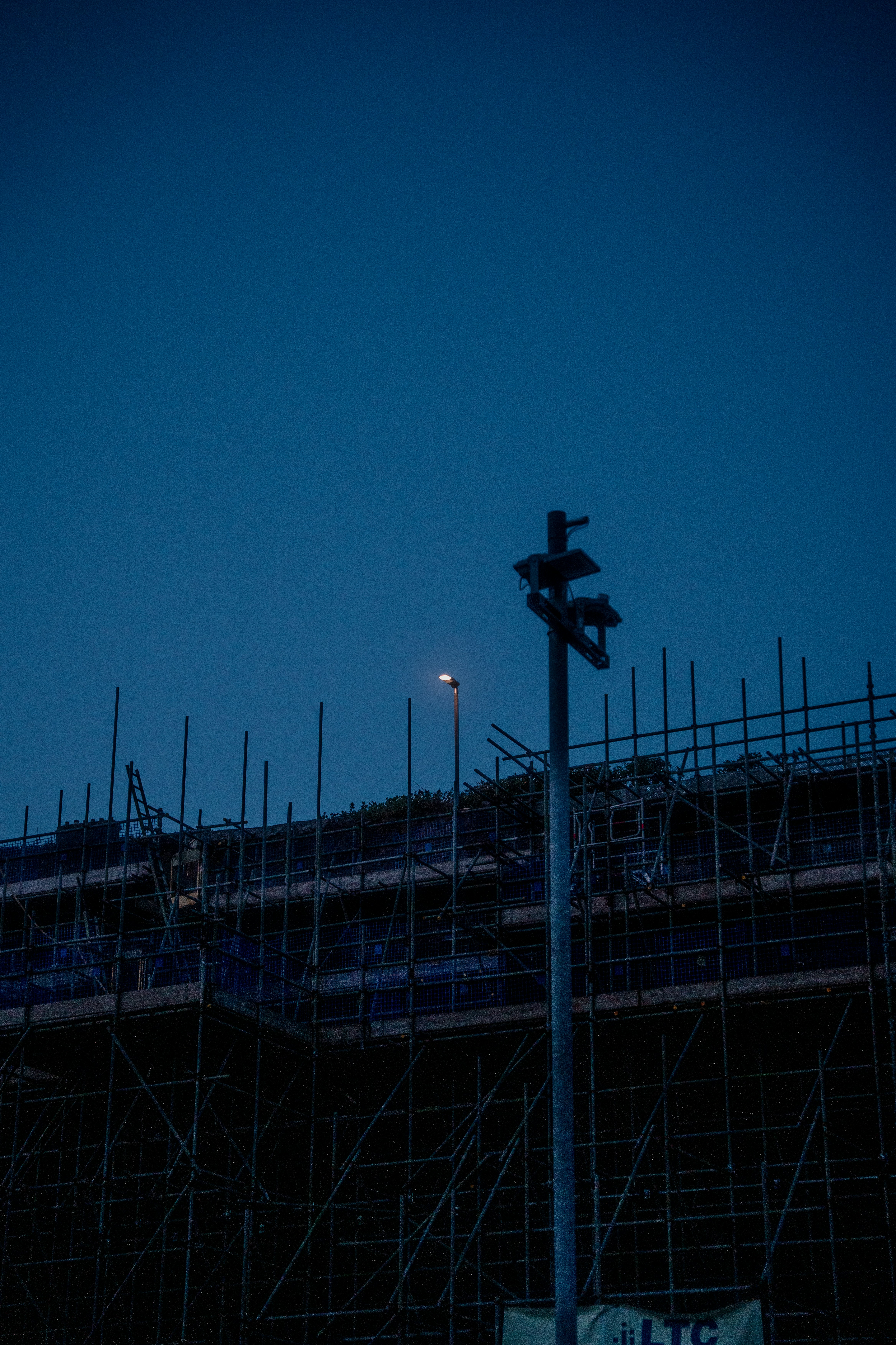 Construction site with scaffolding under a dark blue sky