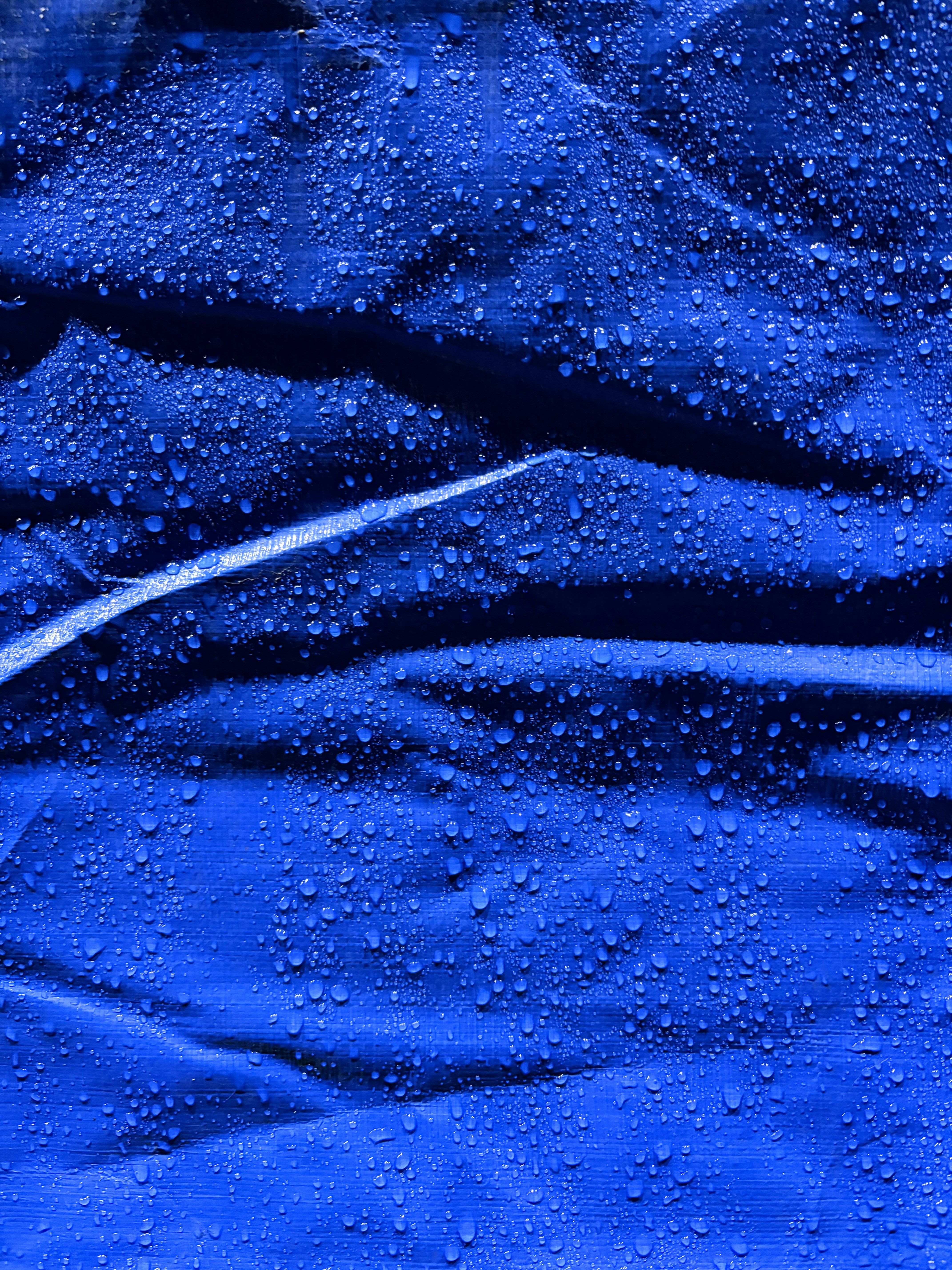 青い布に水滴が落ちるクローズアップ
