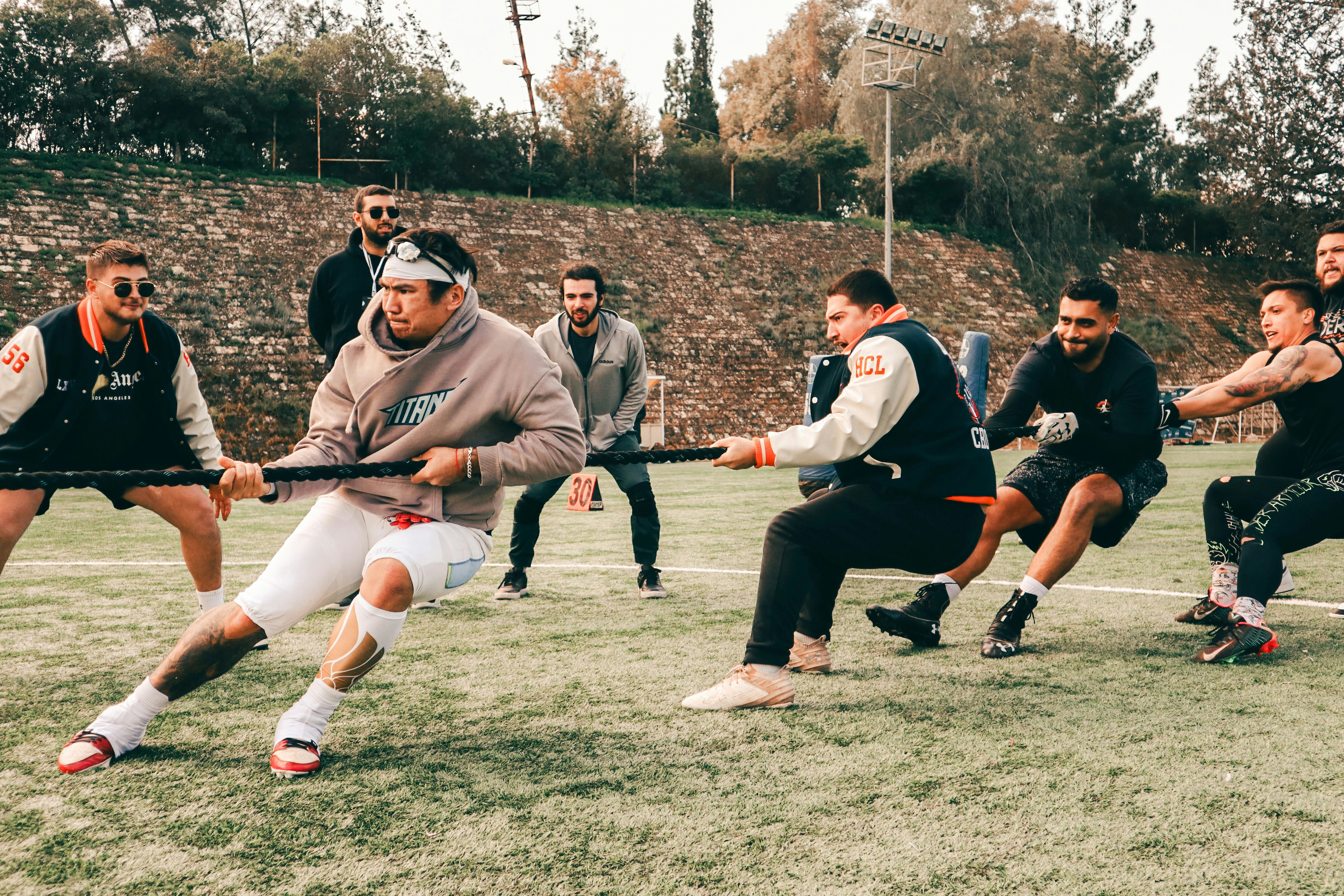 Men playing tug-of-war on a grassy field