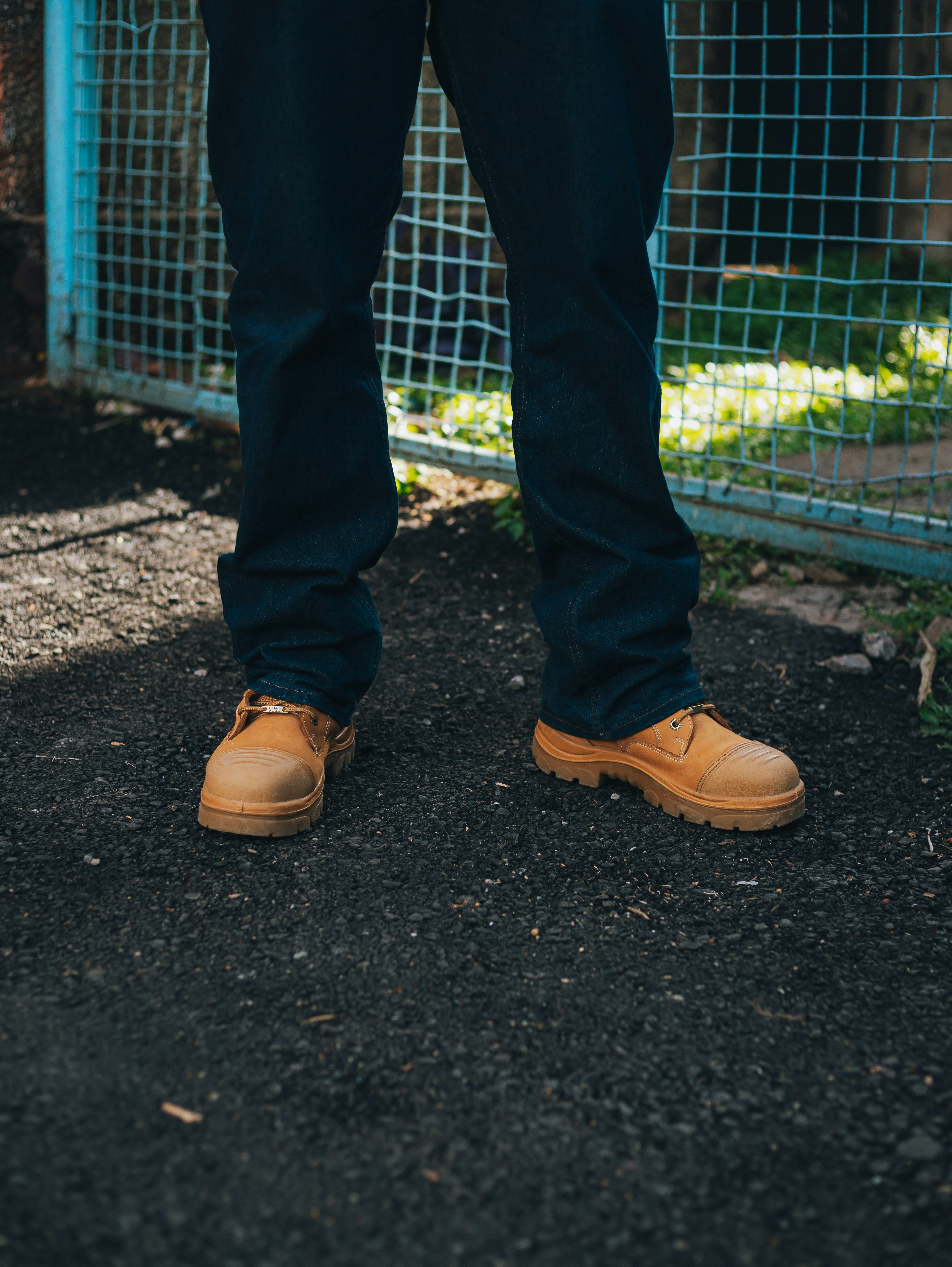 Person wearing dark jeans and tan work boots
