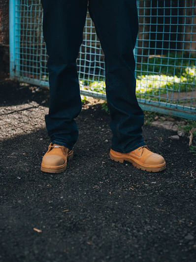 Person wearing dark jeans and tan work boots