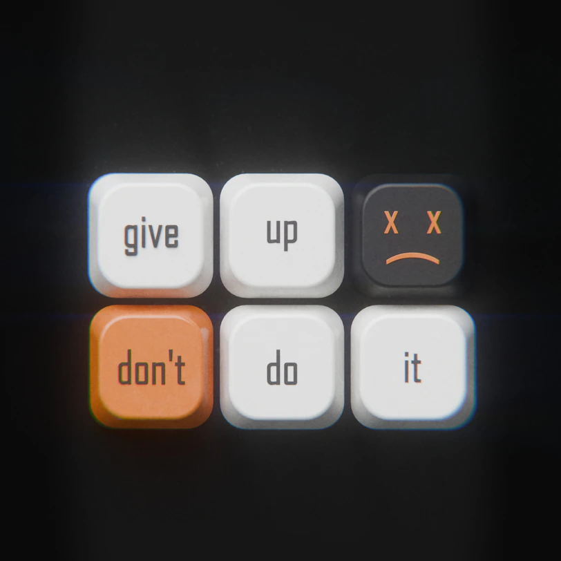 Computer keys arranged to read give up and don't do it with a sad face