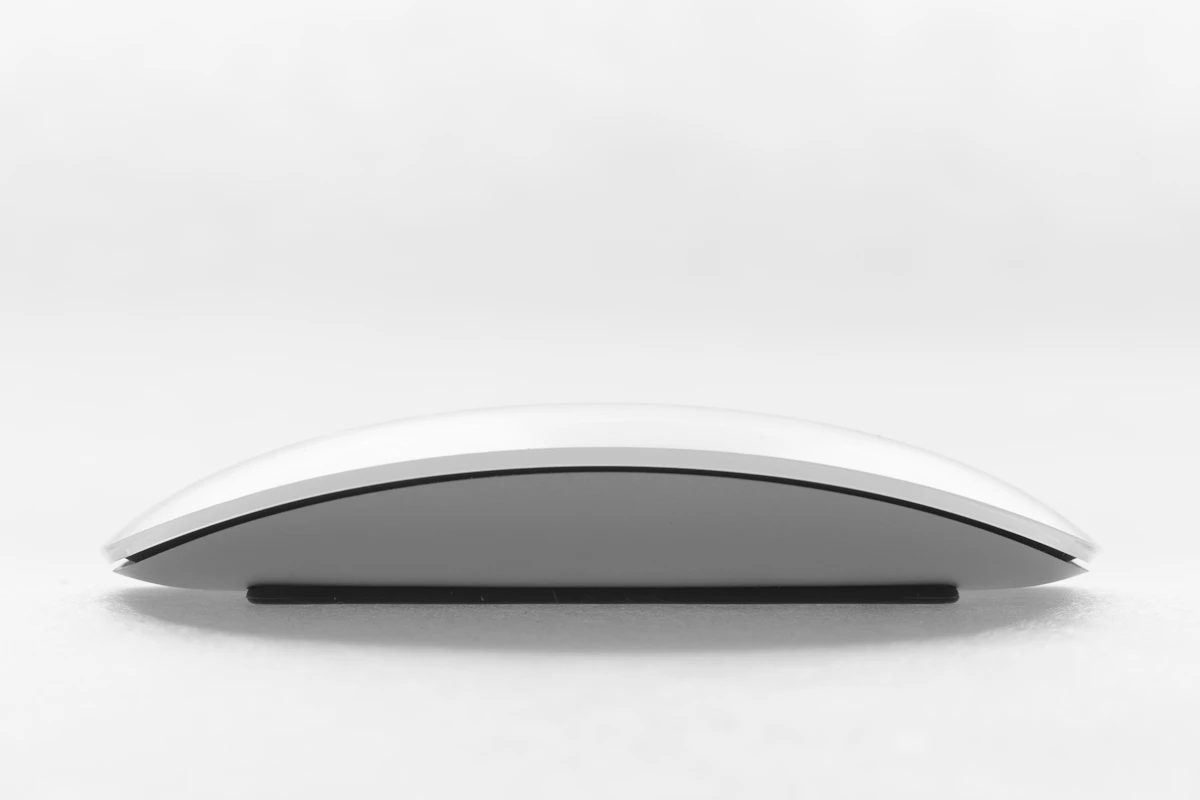Black wireless travel mouse photographed at a three-quarter angle on a seamless white studio background.