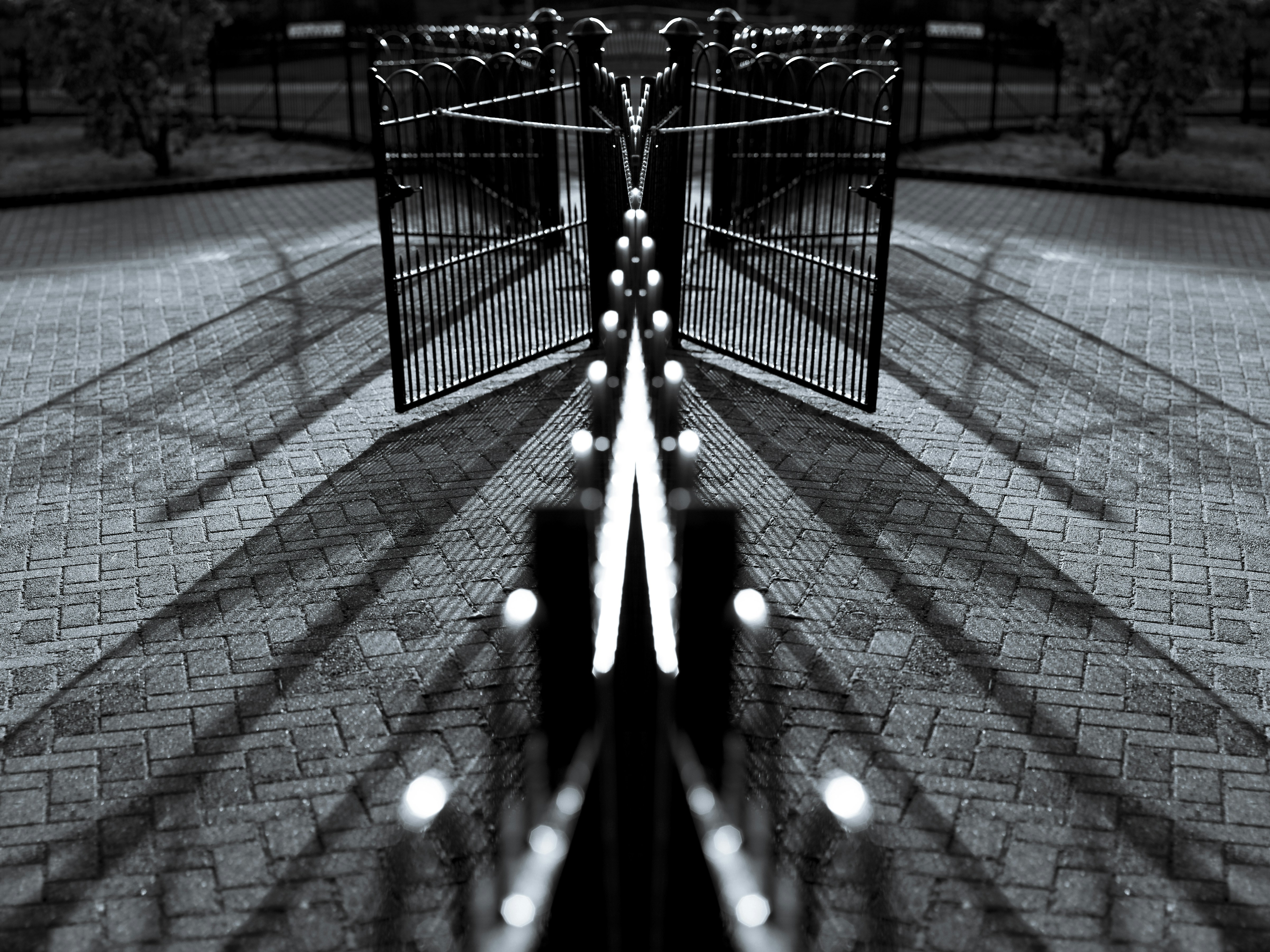 Symmetrische Ansicht eines offenen Tores mit langen Schatten.