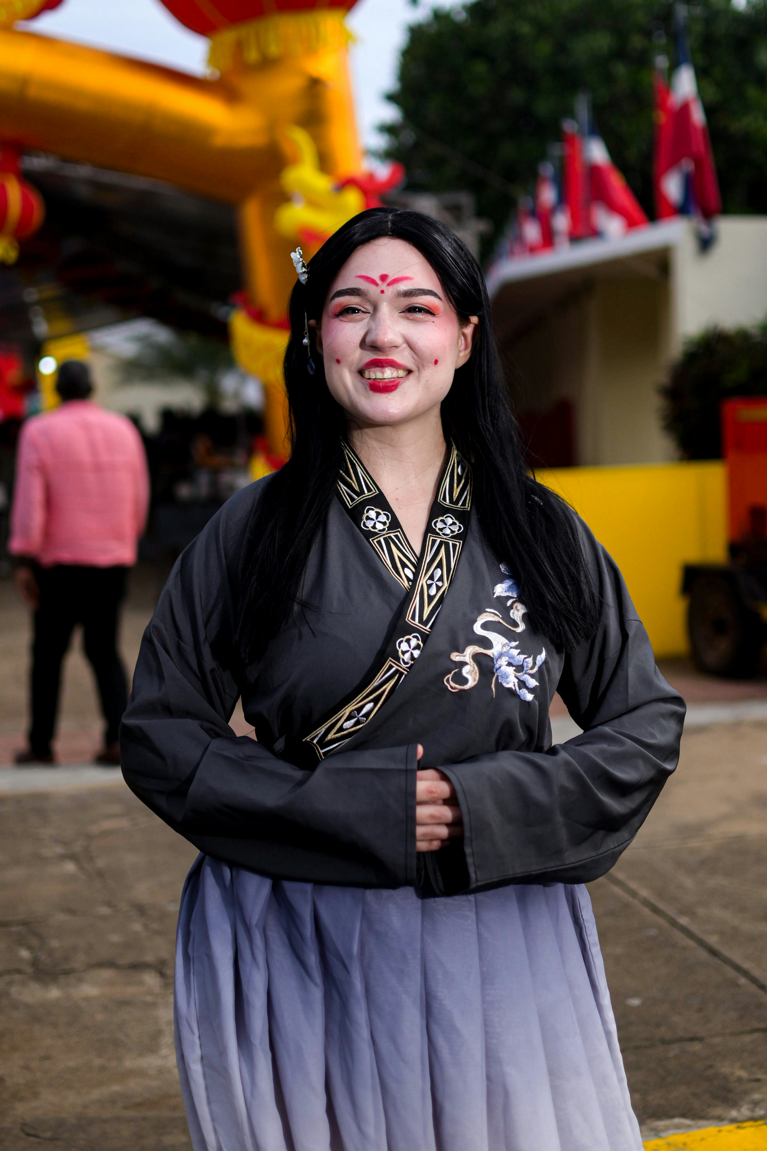 Wanita berpakaian tradisional Cina dengan cat wajah tersenyum