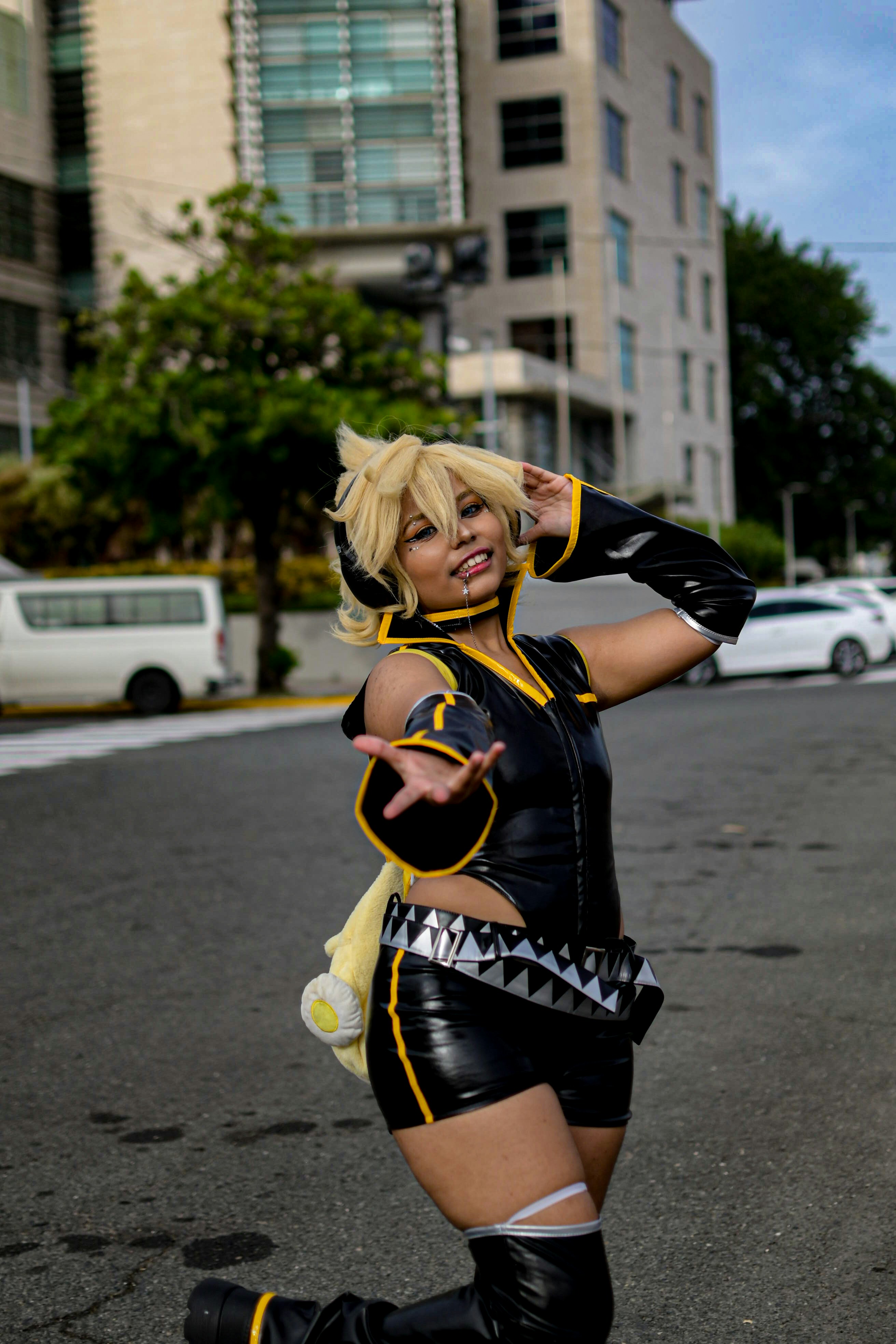 Wanita dengan pakaian cosplay hitam dan kuning di jalan