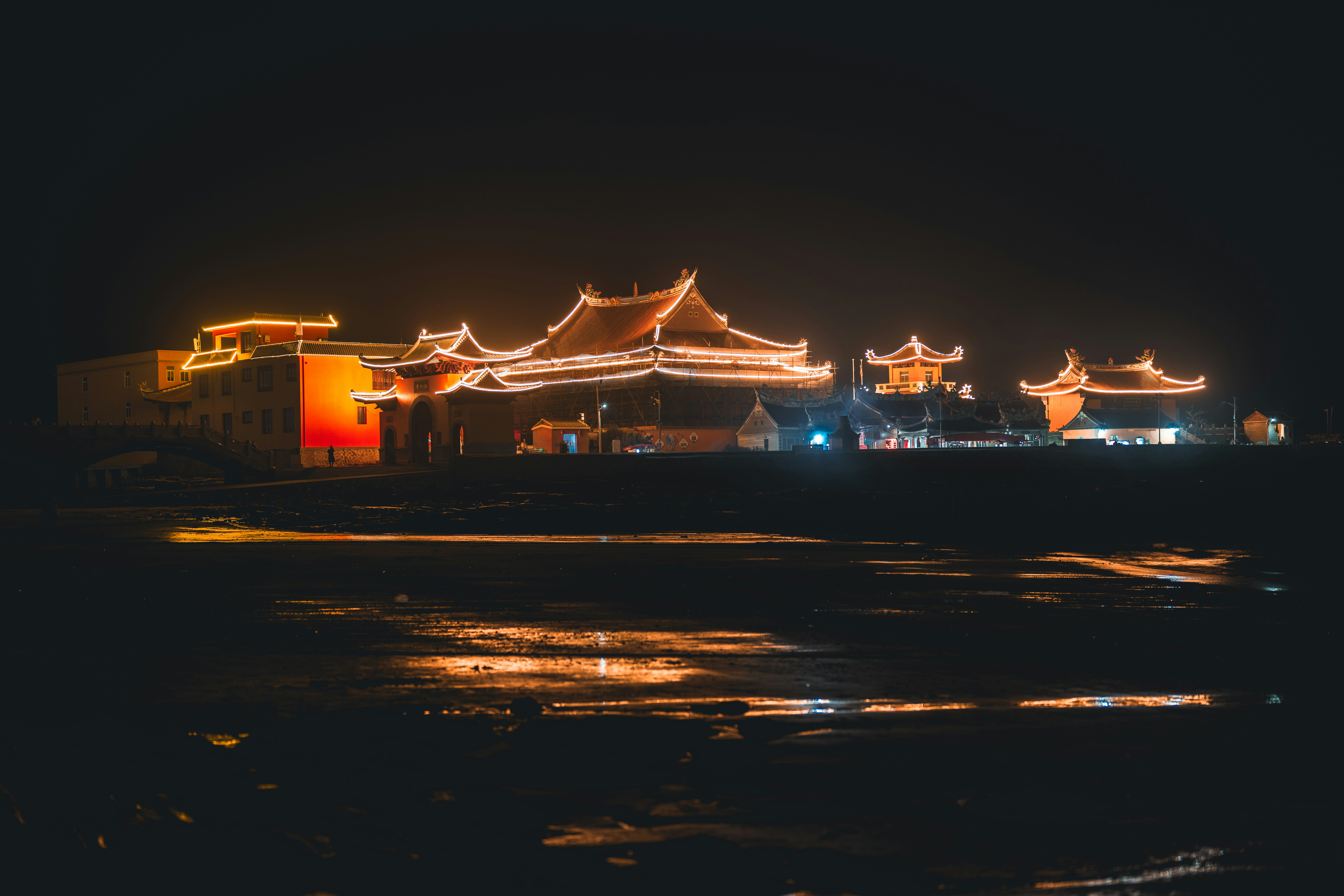 Edificios tradicionales ornamentados iluminados con luces por la noche.