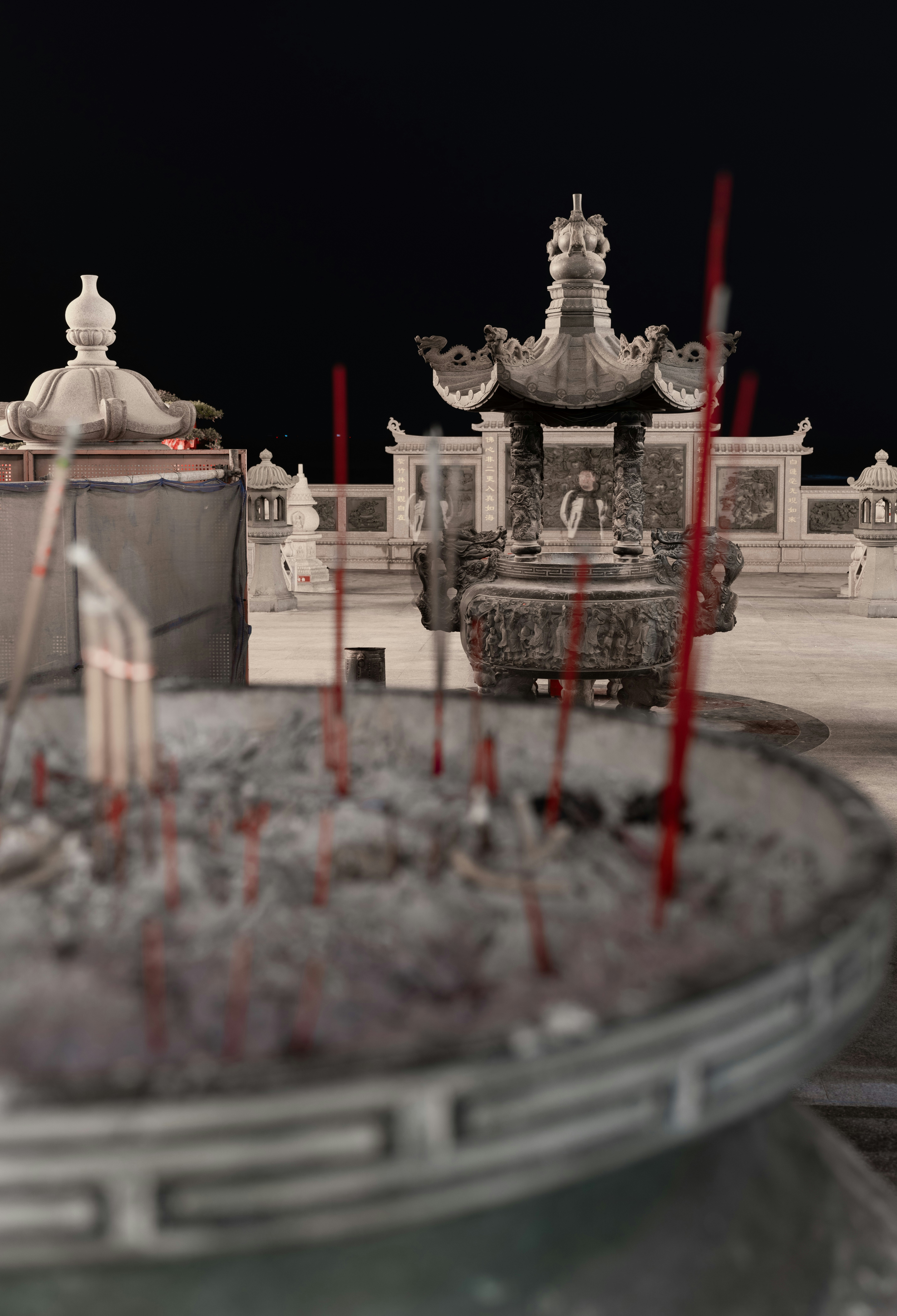 Palos de incienso ardiendo en una urna exterior por la noche