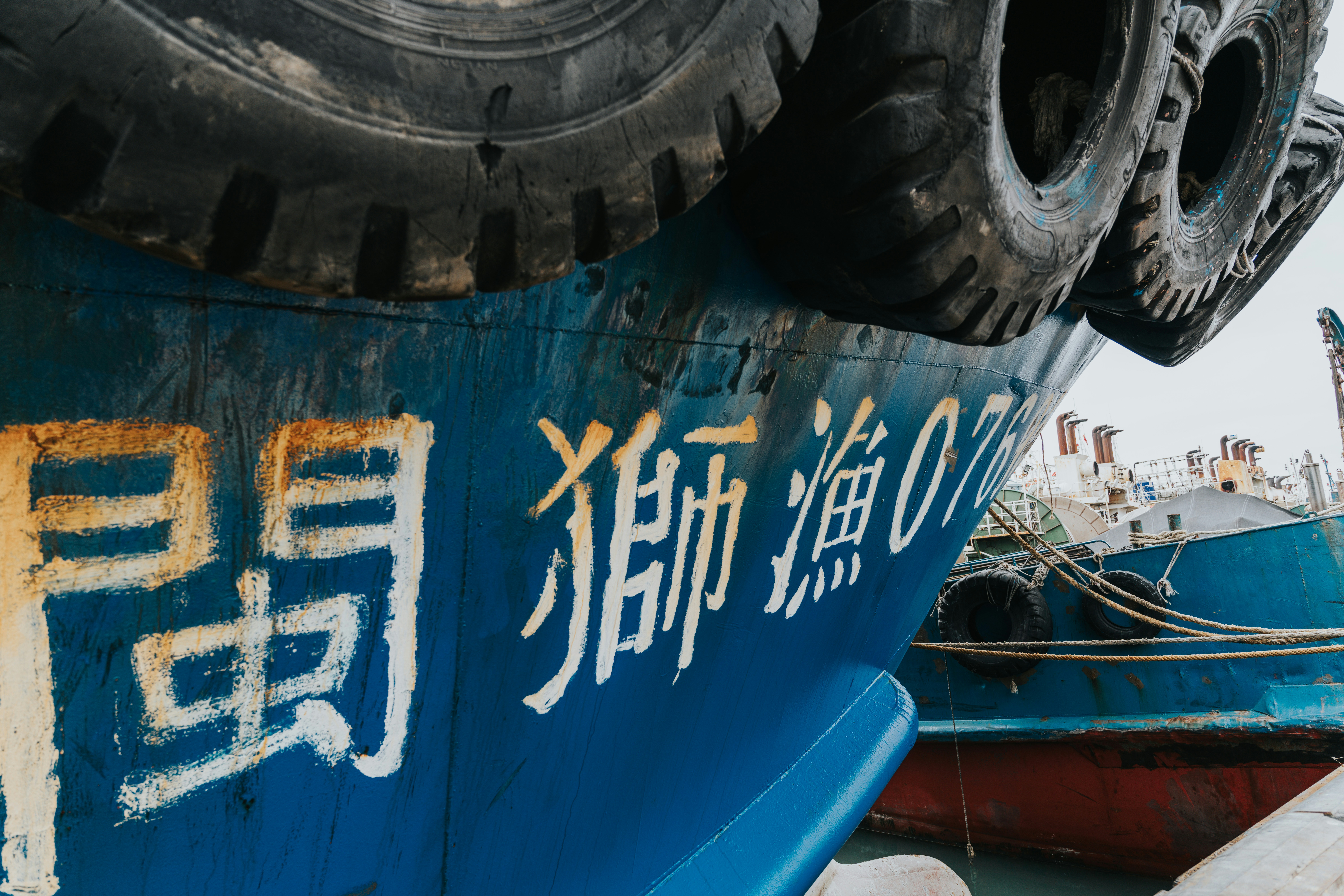 Blue fishing boat with chinese characters and tires