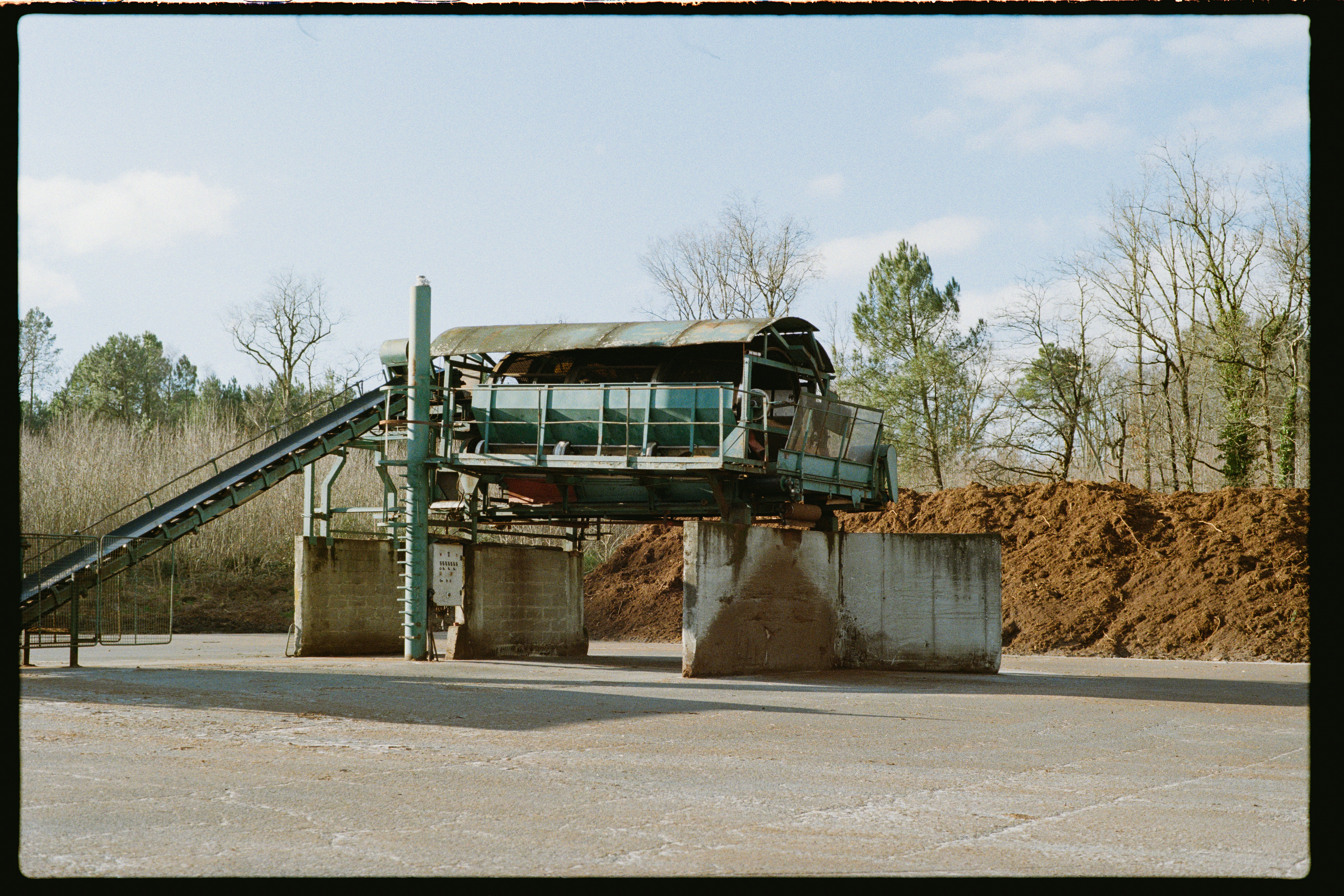 Machines industrielles avec tapis roulants et piles de matériaux