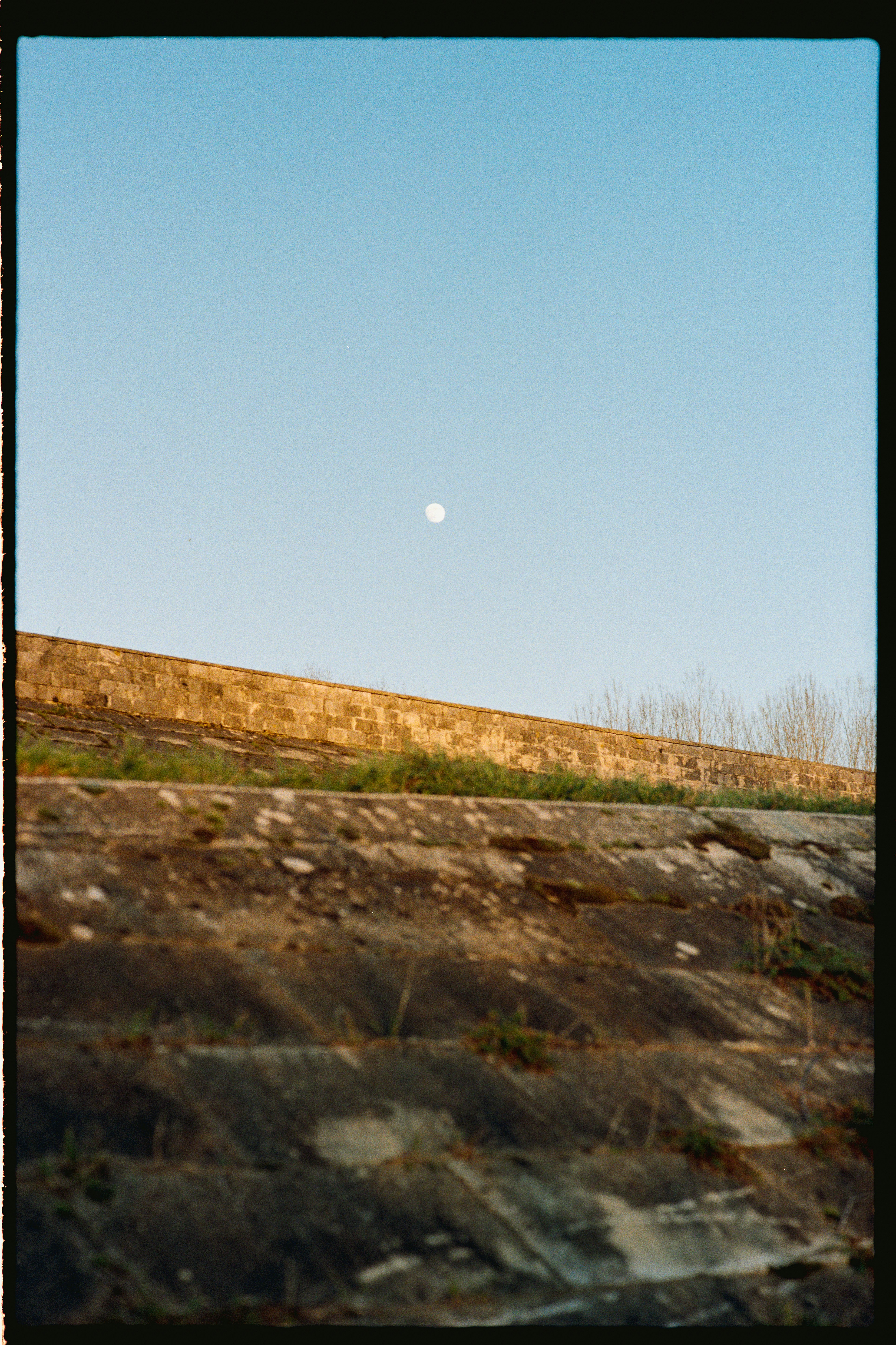 Pleine lune dans un ciel bleu clair au-dessus du mur